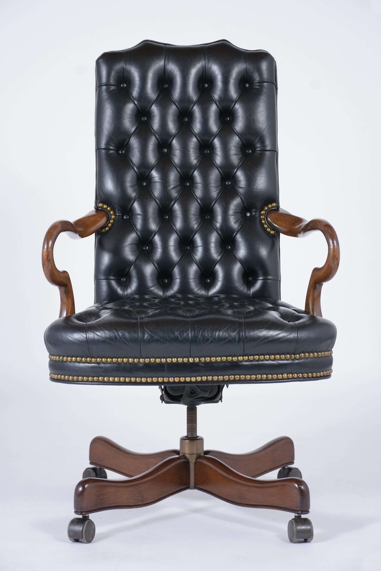 A 1980s Chesterfield style office chair crafted maple wood finished in a walnut color with a newly lacquered finish and is completely restored. The reclining chair is upholstered in its original tufted leather and has been professionally dyed a new
