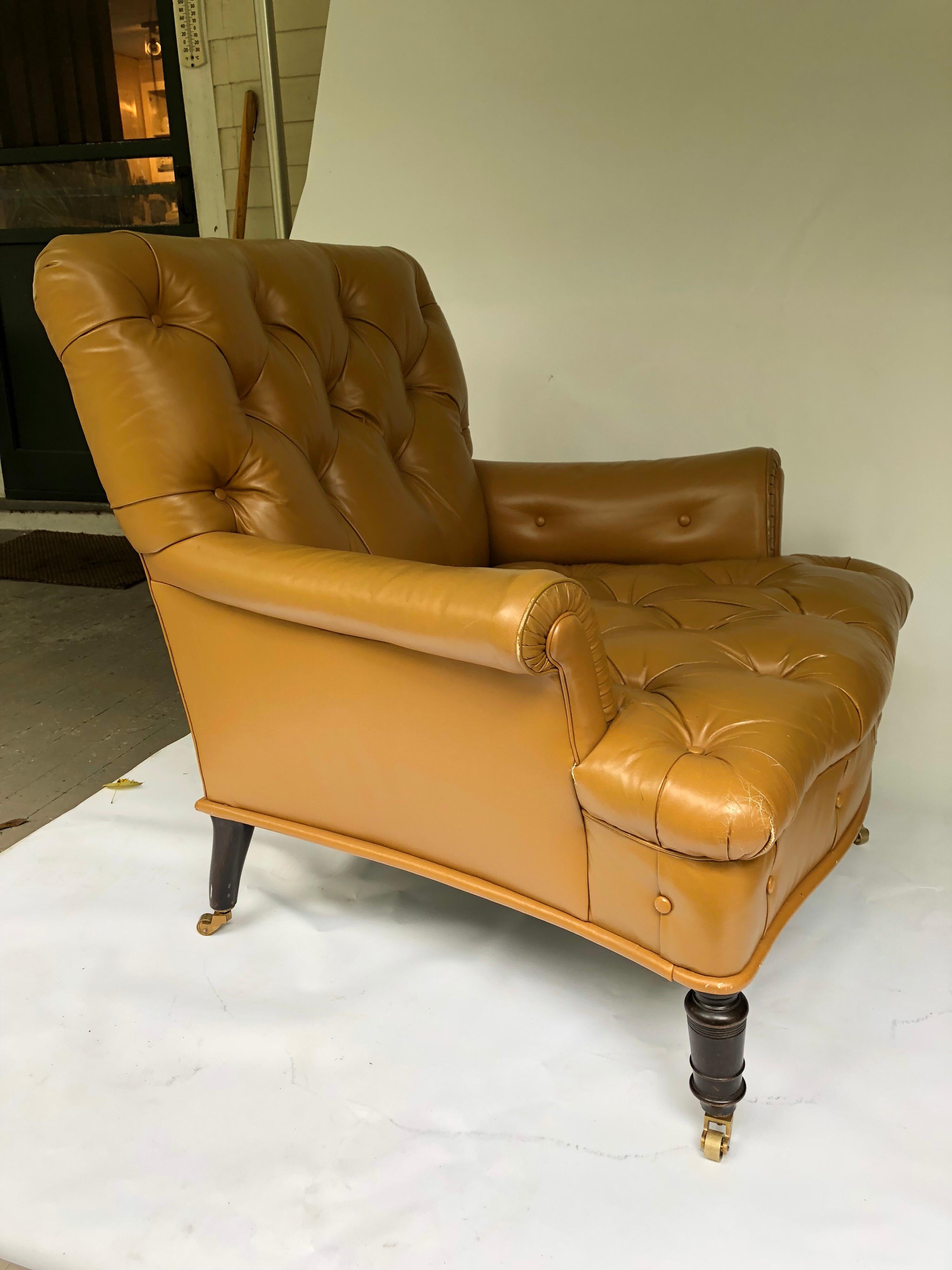 Handsome mahogany tufted leather upholstered library chair, designed by Peter Marino.
On casters. Caramel colored leather, piping and covered buttons.