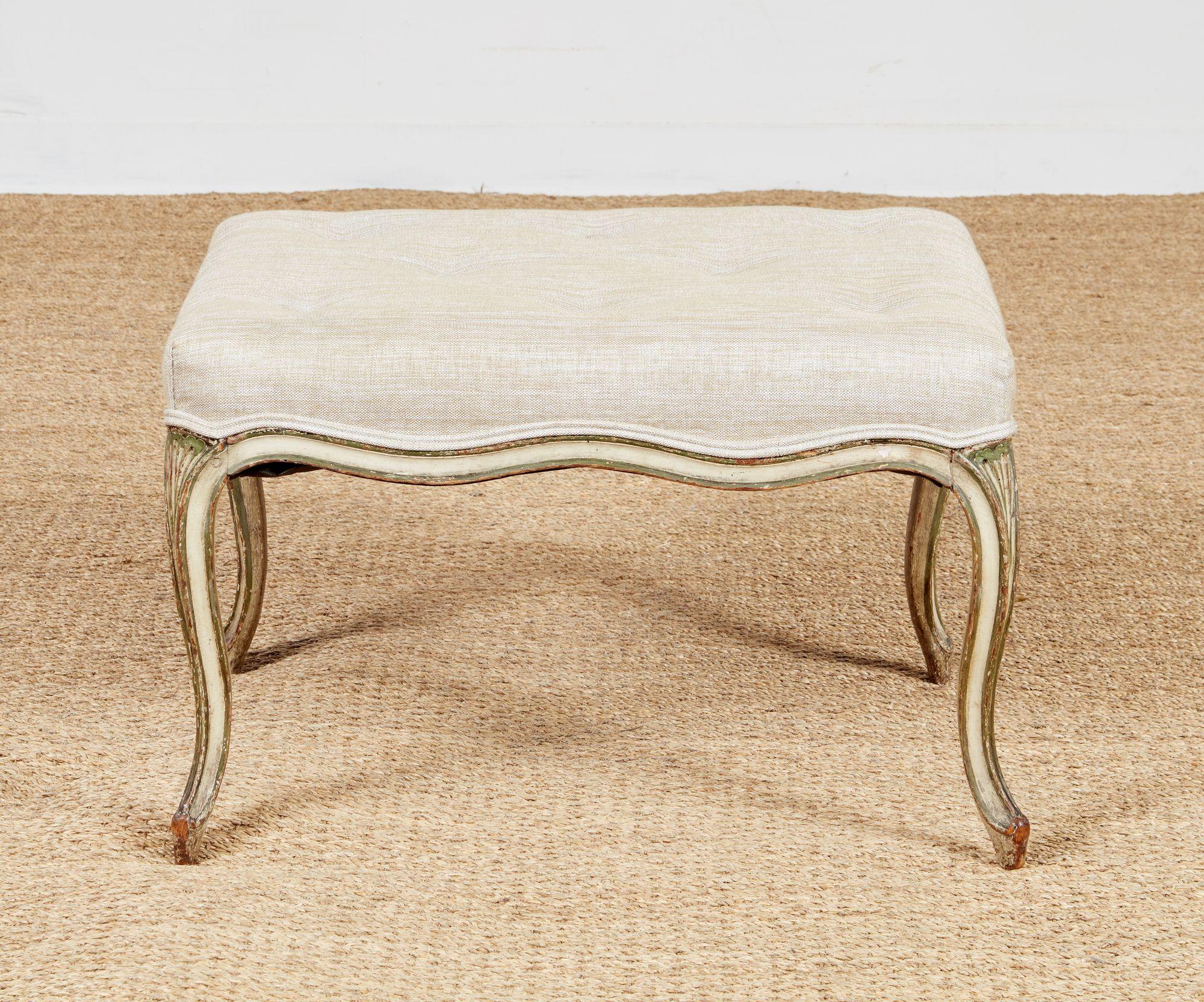 Un joli tabouret ou ottoman rembourré du XVIIIe siècle, léger et aéré. Une pièce élégante avec un tablier et des pieds sculptés en forme d'épingle à cheveux en peinture bleu-gris avec des touches de dorure, rehaussée par la tapisserie et le