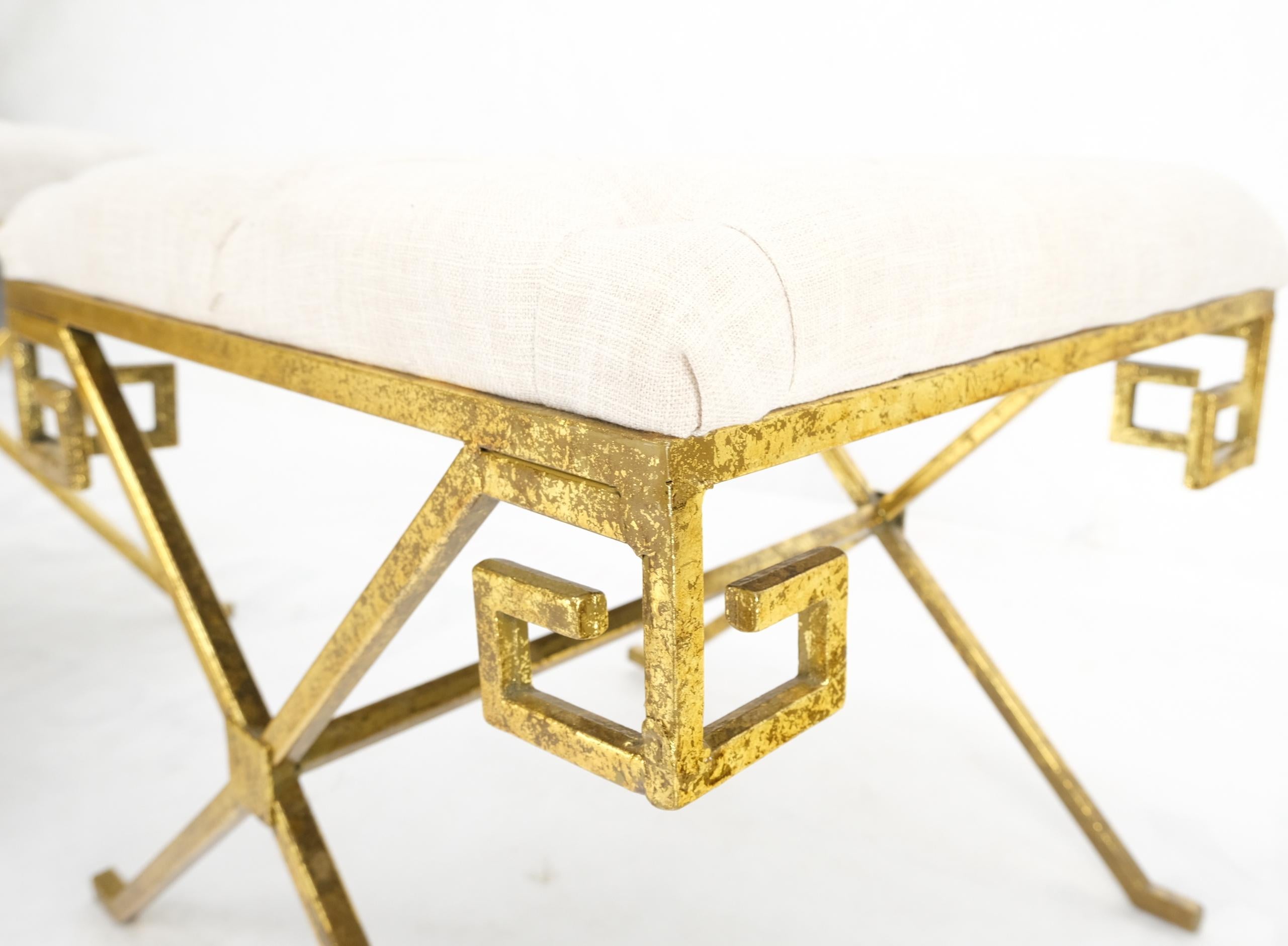 Tufted linen upholstery forged gold gilt steel pair of square x-base Greek key motive benches.