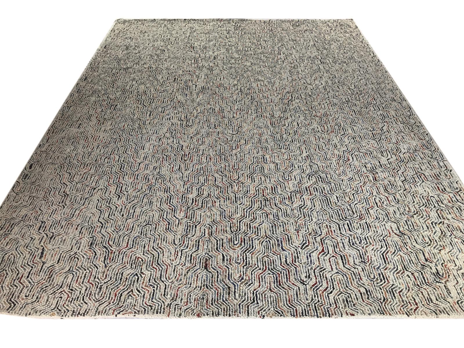 Prenez un motif dynamique et ajoutez un arc-en-ciel de couleurs, et vous obtiendrez ce tapis en laine touffeté unique et étonnant. Le rouge, l'orange, le jaune et les multiples nuances de vert et de bleu ondulent d'un bout à l'autre de cette pièce