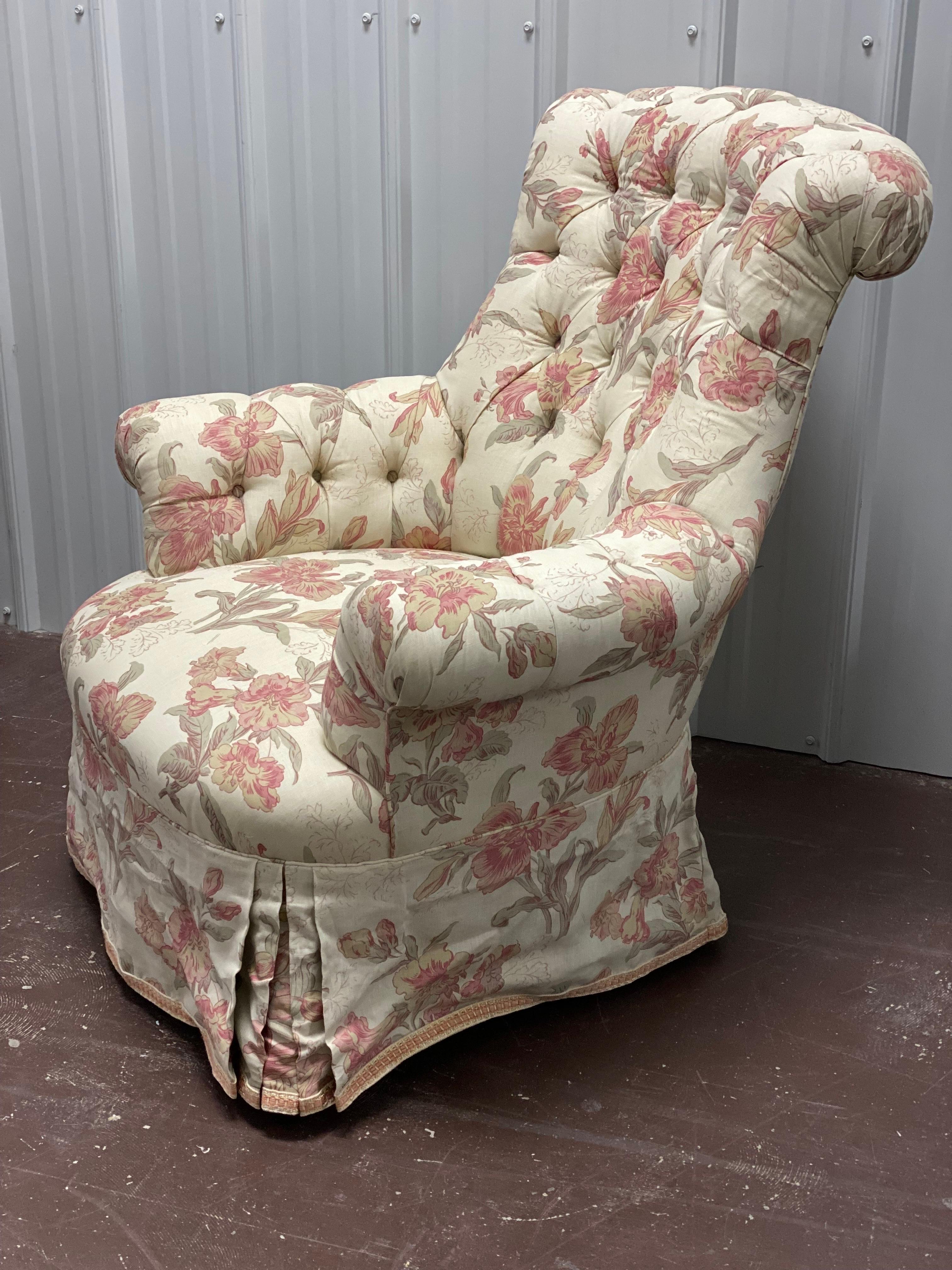 Tufted Rounded Back Armchair designed by Parish-Hadley.
A classic form in the floral linen. Chair designed by Parish-Hadley. Tufted, Rolled-back and arms, tight seat with straight skirt, pleated at corners. Tape trim applied along base of skirt.