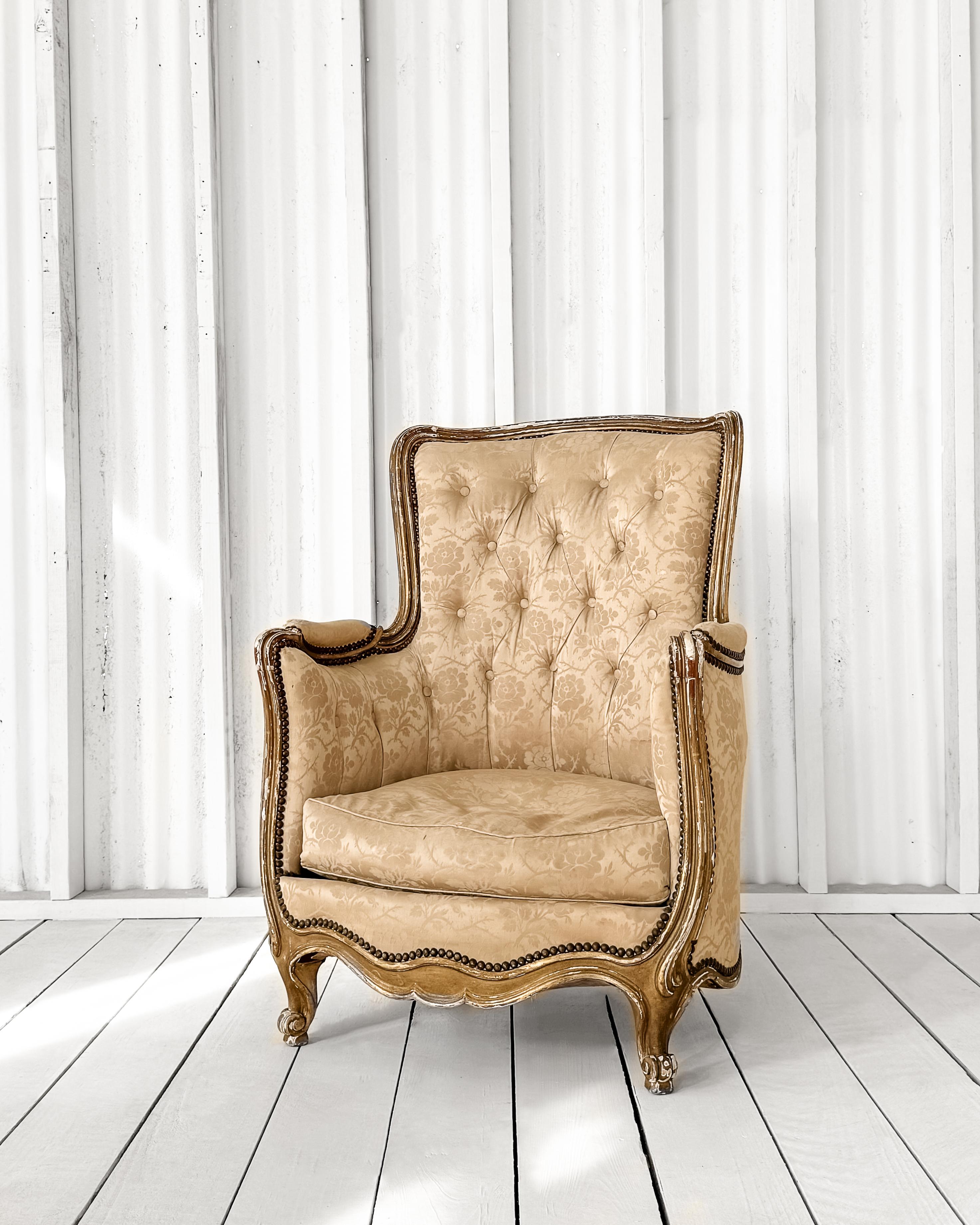 This French Louis XV Bergère style armchair is a masterpiece of craftsmanship from the early 19th century. The hand-molded frame and barrel back exhibit meticulous attention to detail, showcasing the artistry of pinned mortise and tenon