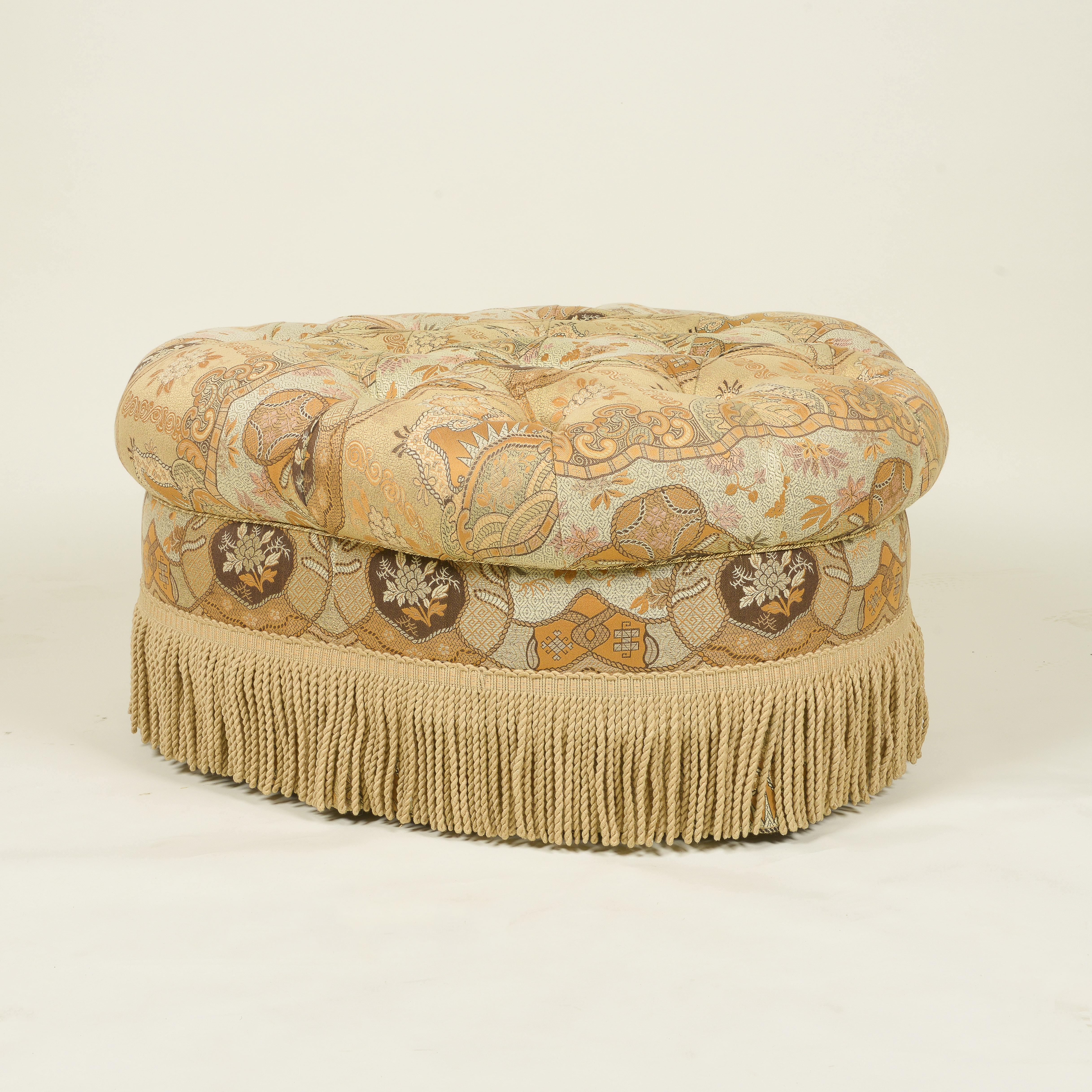 The tufted seat covered in an arabesque patterned woven silk; with bullion fringe and skirt; on dark wood square tapering feet.
