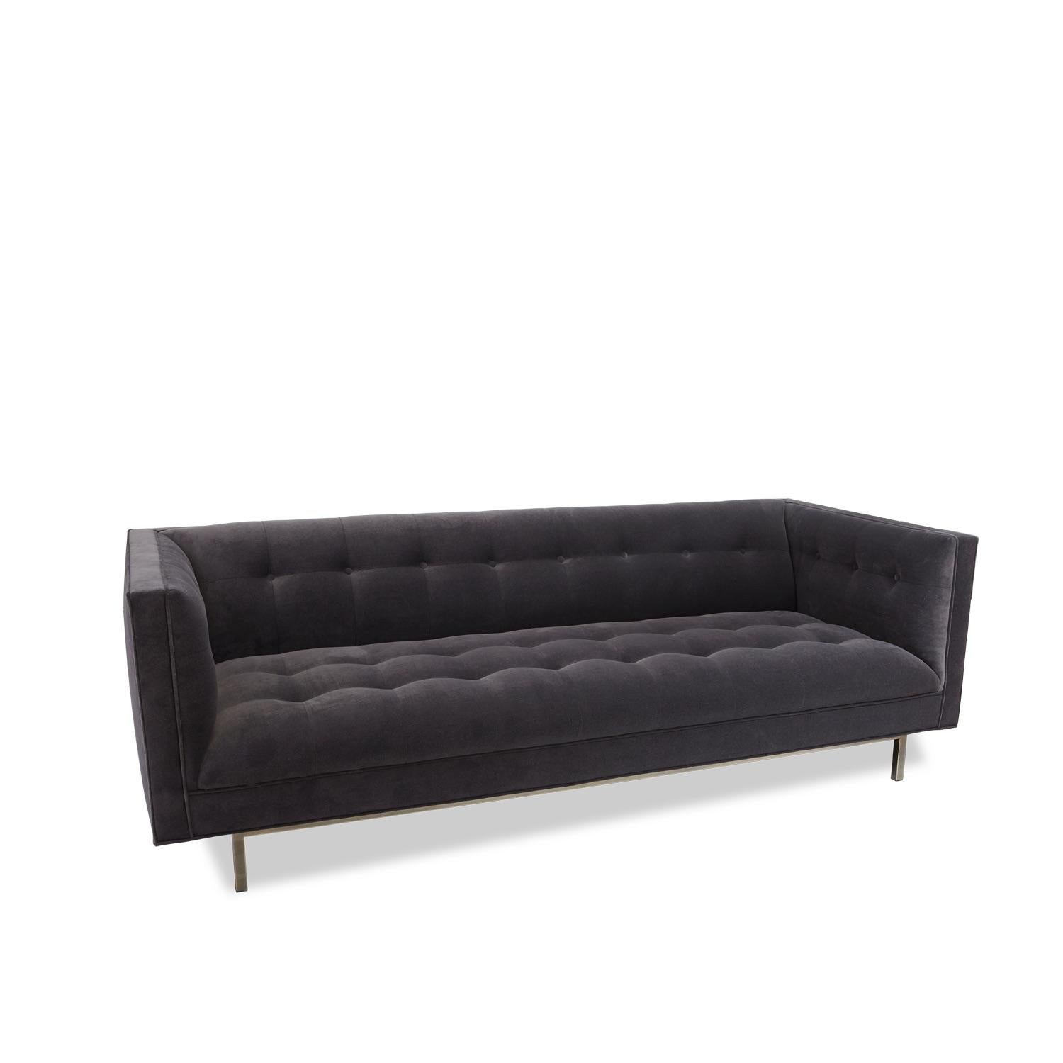The Trousdale sofa features a tufted body, arms and seat with attached cushions. The recessed square base and legs are made of solid American walnut or white oak. Shown here in velvet with an antiqued brass base

The Lawson-Fenning Collection is