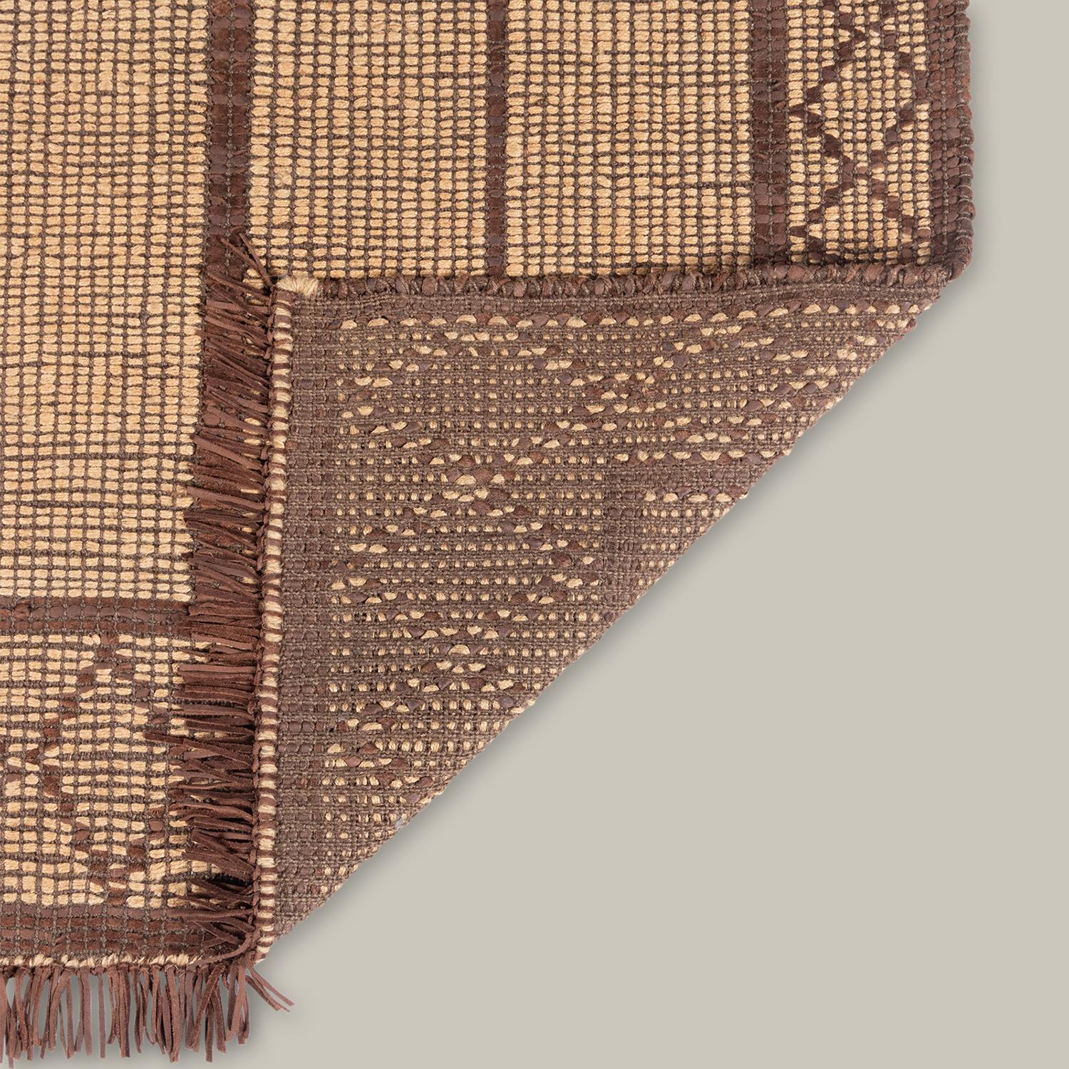 La Colección Tugart, un giro moderno de las tradicionales esteras tuareg, celebra la elegancia en el minimalismo. Históricamente construida para resistir el desgaste, la construcción de cuero y yute tejida a mano envejece con gracia. Una textura