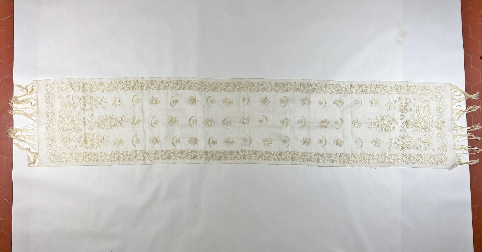 Circa 1900-1920
Ottoman Empire
Beautiful Turkish scarf in cream silk organza densely embroidered tone on tone with floche silk thread dating from the early 20th century. Drawing of a stream of garlands of flowers with calligraphic inscriptions,