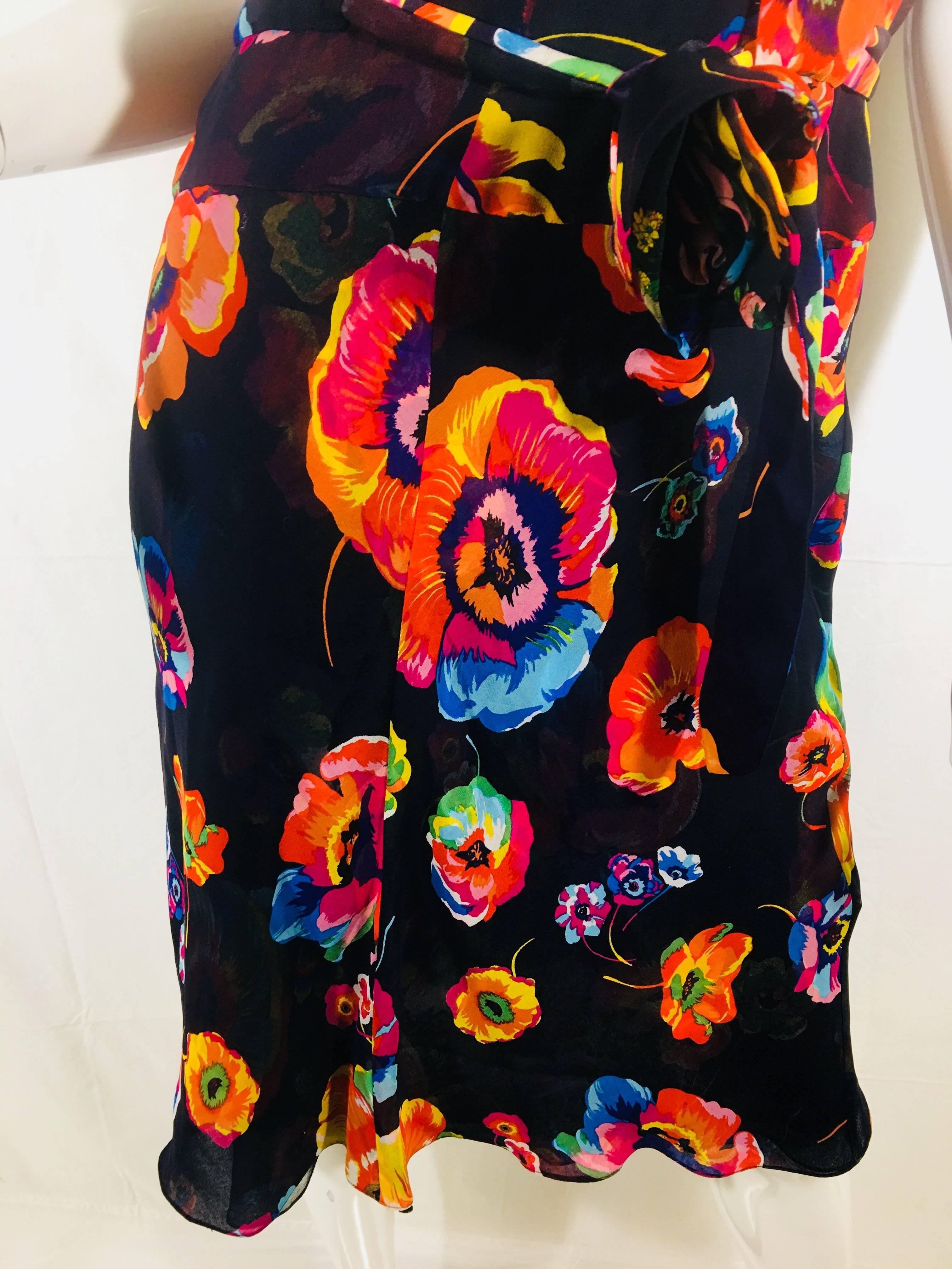 Tuleh Cap Sleeve Dress with V-Neck. Knee Length, Vibrant Floral Print, Button Up Back and Tie Around Waist with Flower Detail.
One Button Loop Needs Mending.
