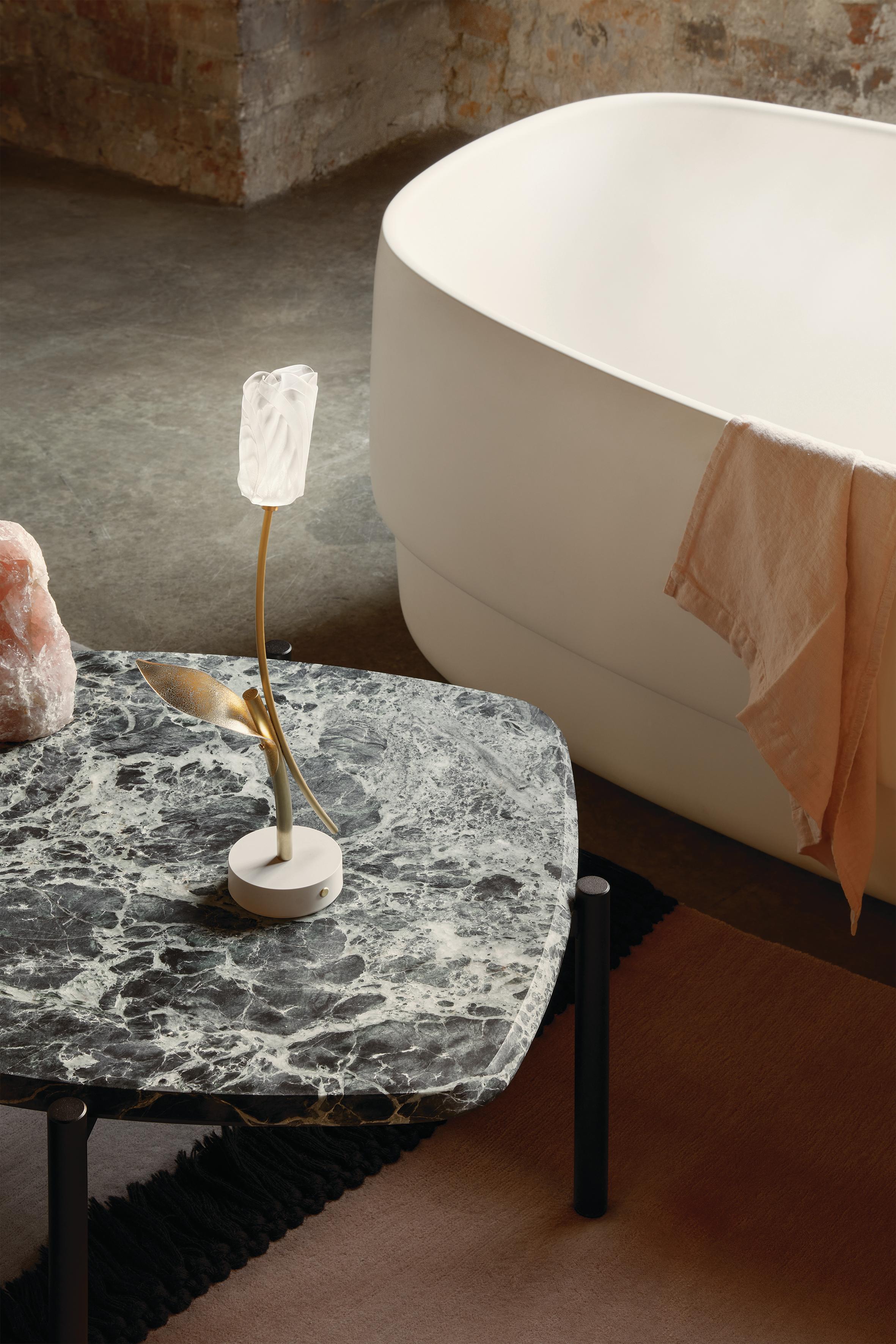 Tulip, installation lumineuse romantique de Marc Sadler, est proposée en version de table avec batterie rechargeable, qui peut être déplacée d'un simple geste pour offrir des scénarios toujours nouveaux. La tige en aluminium anodisé supporte une