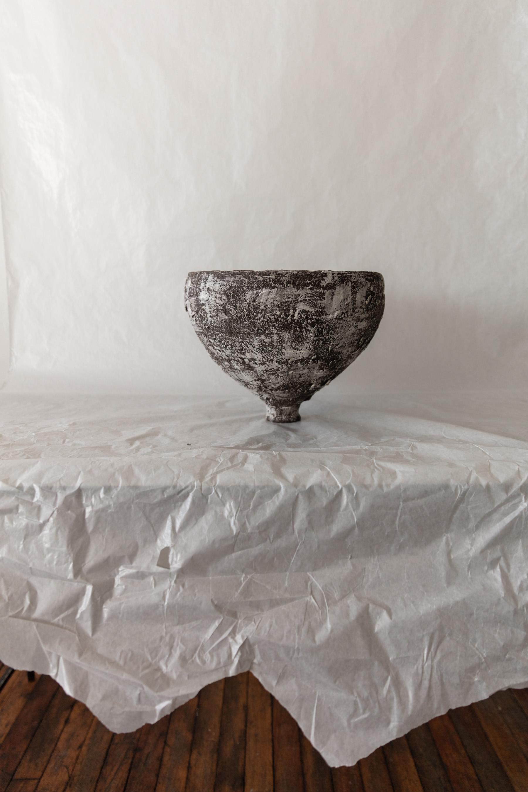 The Tulip Bowl is a one-of-a-kind handcrafted creation by Ilona Golovina, showcasing her unwavering dedication to emphasizing imperfection. 

Crafted from dark sculpture clay, with a white terra sigillata brushed detail that smartly displays the