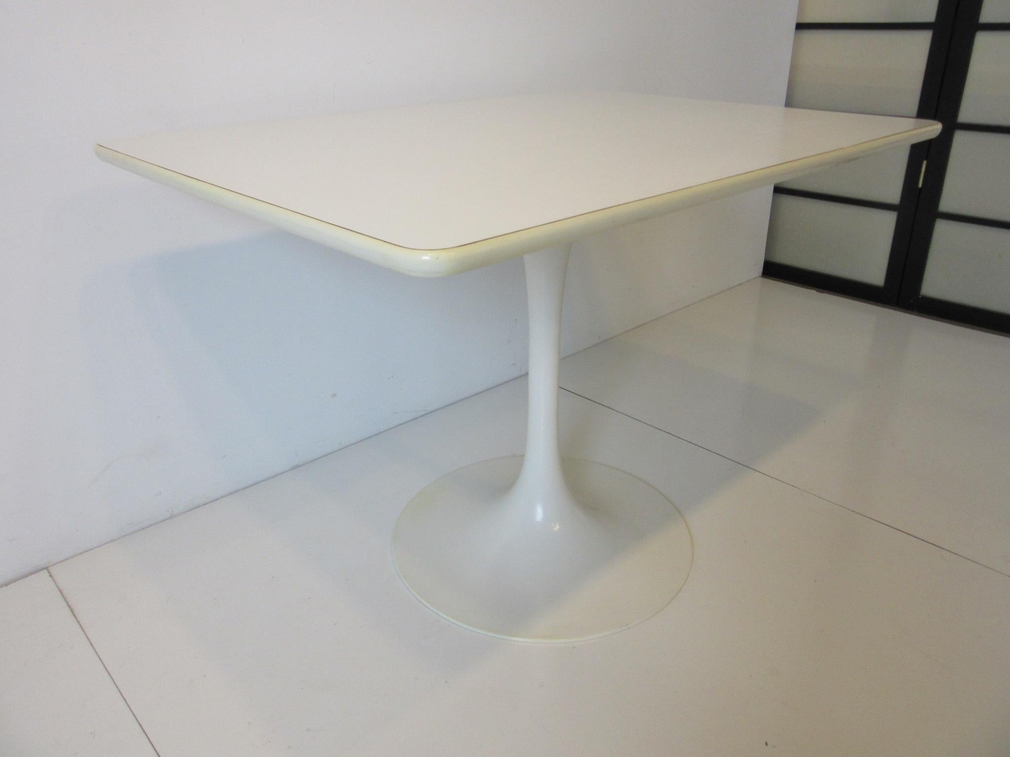 A hard to find rectangle tulip based cafe or smaller dining table with white laminate top, rubber edge strip and metal base. Manufactured by the Burke Furniture company, the perfect size for your eat in kitchen or a smaller dining space.