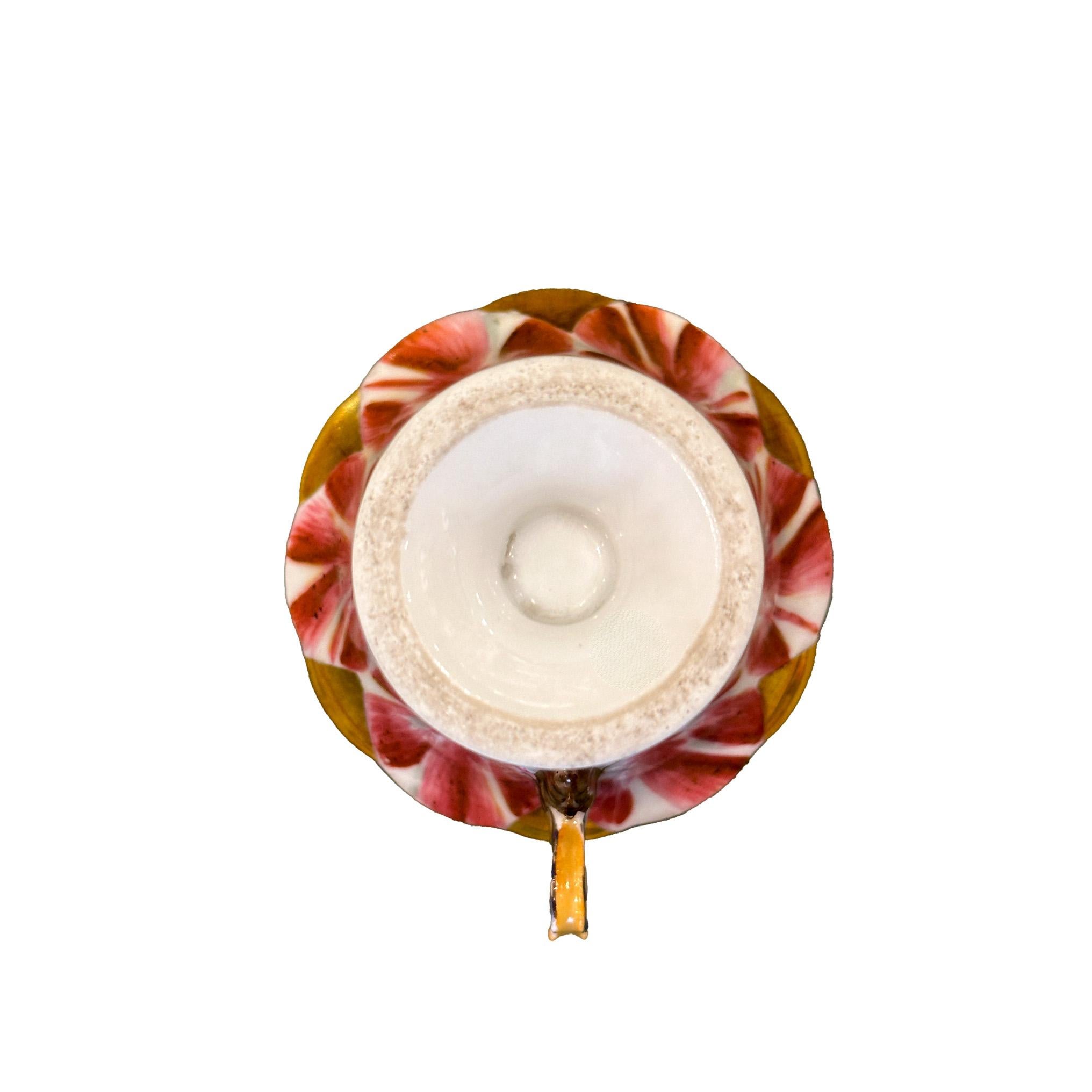 Taza en forma de tulipán con su platillo en porcelana de Old Paris. Piezas pintadas a mano con preciosos tonos morados y blancos, en forma de flor de tulipán. Una pieza muy delicada con asa en forma de mariposa y bordes ligeramente festoneados, que
