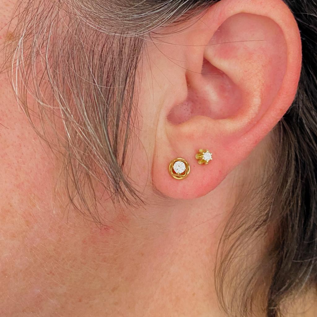 These floral diamond solitaire stud earrings are a sweet statement style on any ear. Each diamond is held in six prongs above scooped curves of gold forming a floral frame presenting each diamond. The friction post and backs are secure and