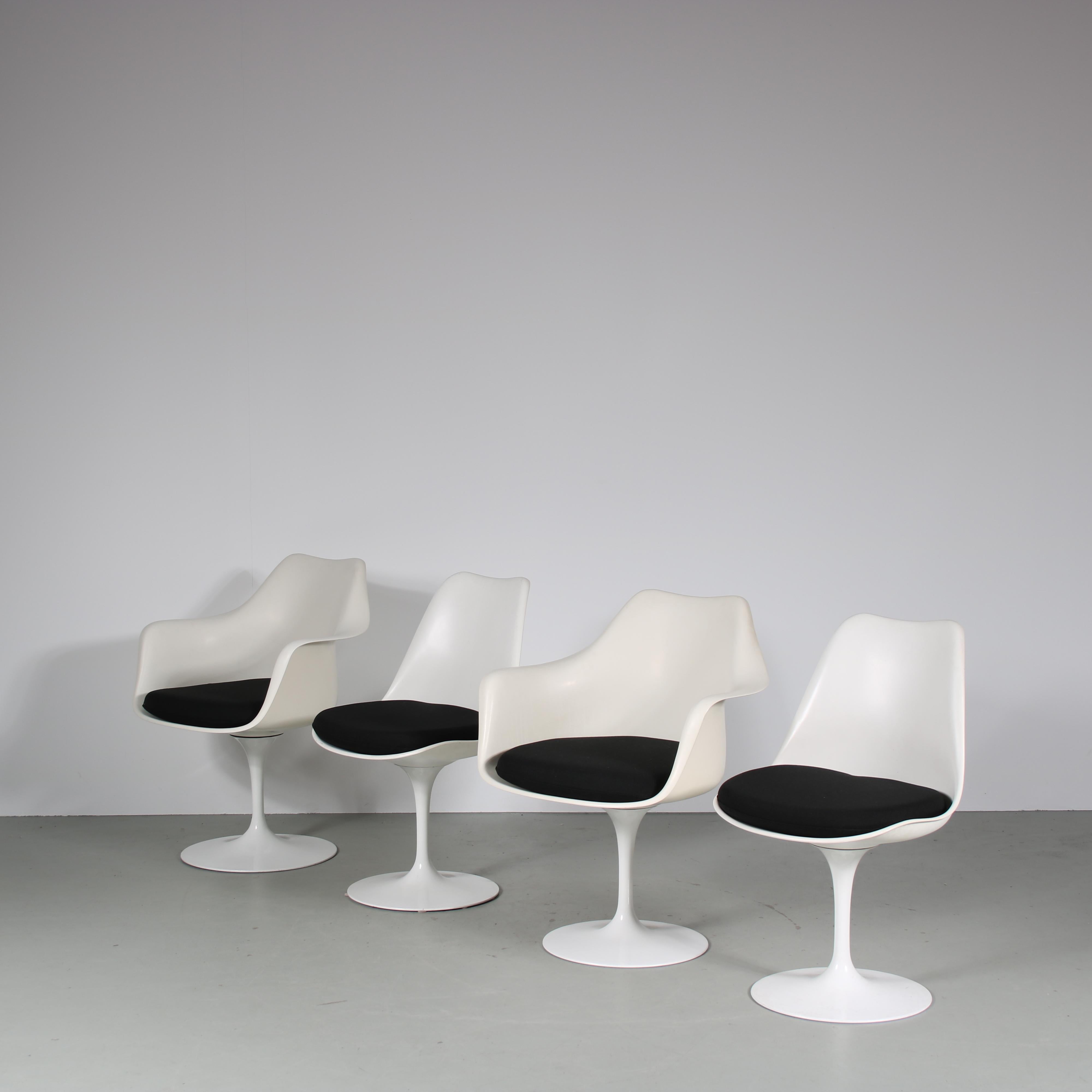 This set of four swivel dining chairs is a true icon of mid-century modern design, designed by Eero Saarinen and manufactured by Knoll International in the 1960s.

The chairs feature a sleek and minimalist tulip base in white aluminum, which