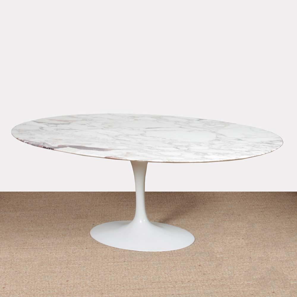This dining table was designed by Finnish-American designer Eero Saarinen. It is the Tulip model, designed in 1956 for Knoll. The tabletop is made of marble and the base is made of cast aluminum covered with white Rilsan. This table from the 1970s
