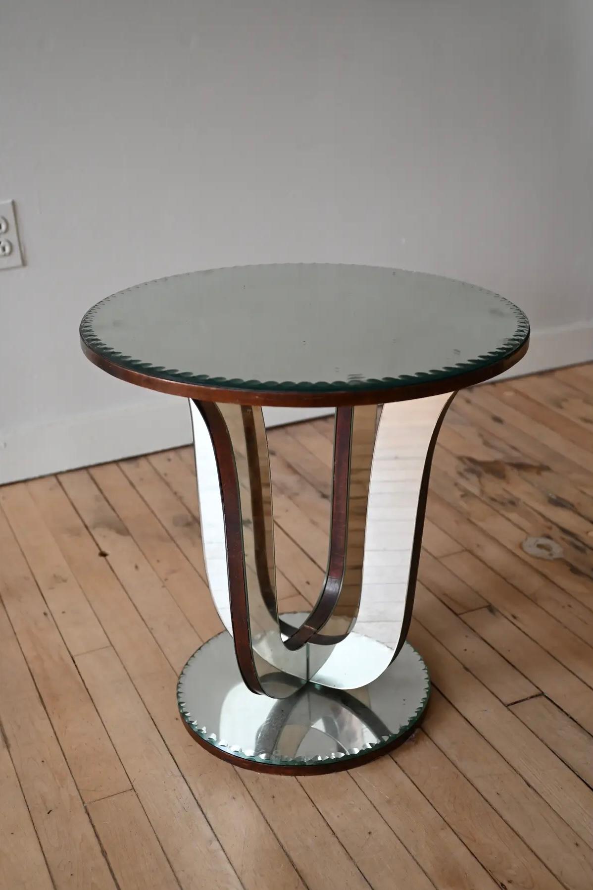 Eye catching French mirrored glass table. Art deco period with a scalloped edge to the glass top and base. Frame is ebonized walnut.  