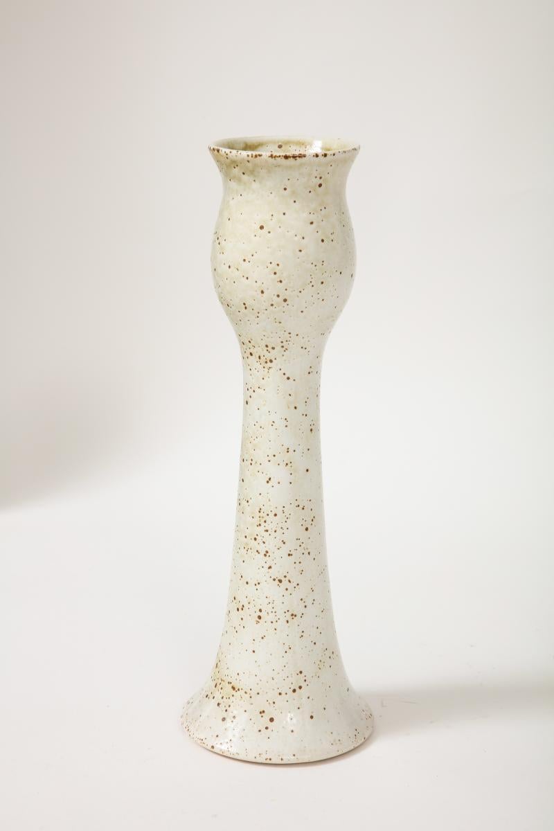 
This tall hand-thrown vase is reminiscent of a tulip or poppy pod. The tall, undulating form would lend well to a grouping; this vase would make a beautiful addition to a ceramics collection.