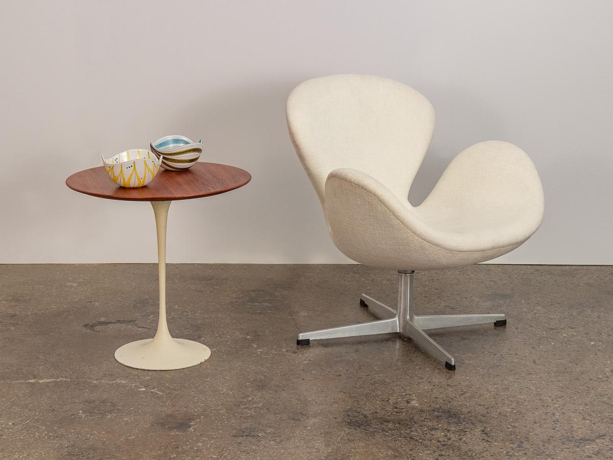 Iconic Eero Saarinen tulip side table in walnut for Knoll. This petite version of the large Saarinen Tulip dining table echoes the organic, drop of liquid form. Despite the size, this side table maintains it's center of gravity; substantial weight