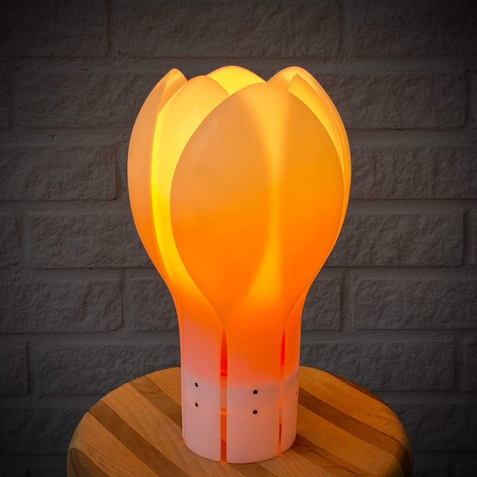 Table lamp ‘Tulip’ designed in the 1970’s by the Swedish architect Yngve Ekström. Made from white acrylic with clear details. It features an orange inner shade that imparts a warm and cozy tone to the light. Electrified with one lamp holder inside