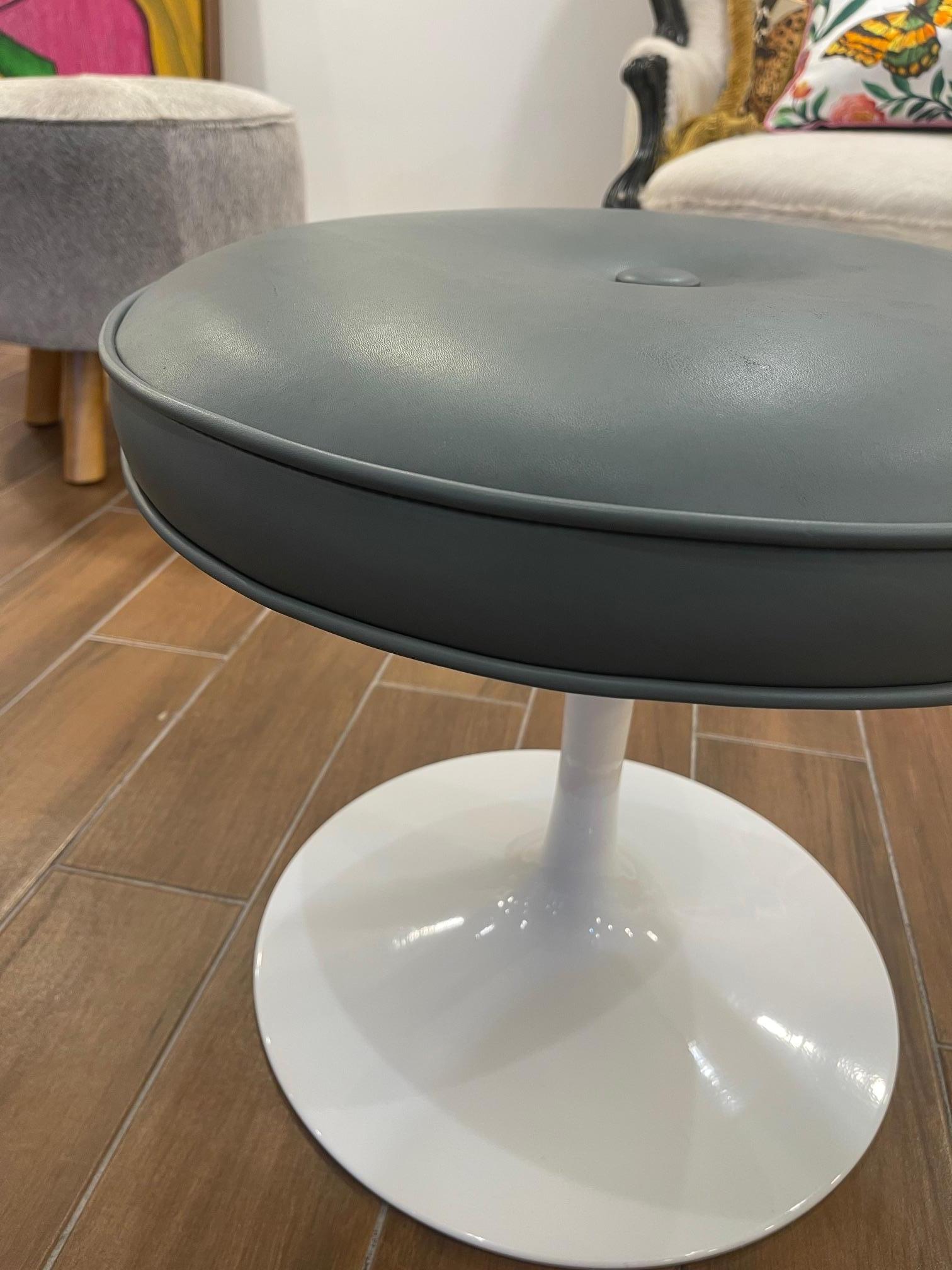 La otomana Tulip equipada con un cuero azul acero gunmetal  es una versión moderna de un clásico muy querido. Con su estructura de acero y su suave cojín superior, es la pieza de acento perfecta.