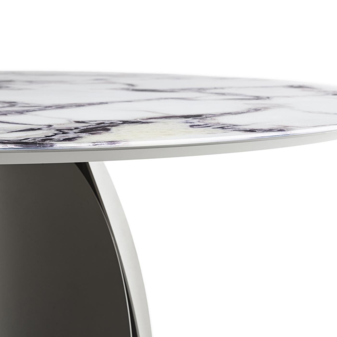Showcasing the faithful print of Trinity marble decorating its tempered glass tabletop, this table celebrates nature through sophisticated modern detailing. The sculptural structure in rolled metal - finished in champagne surging epoxy-powder