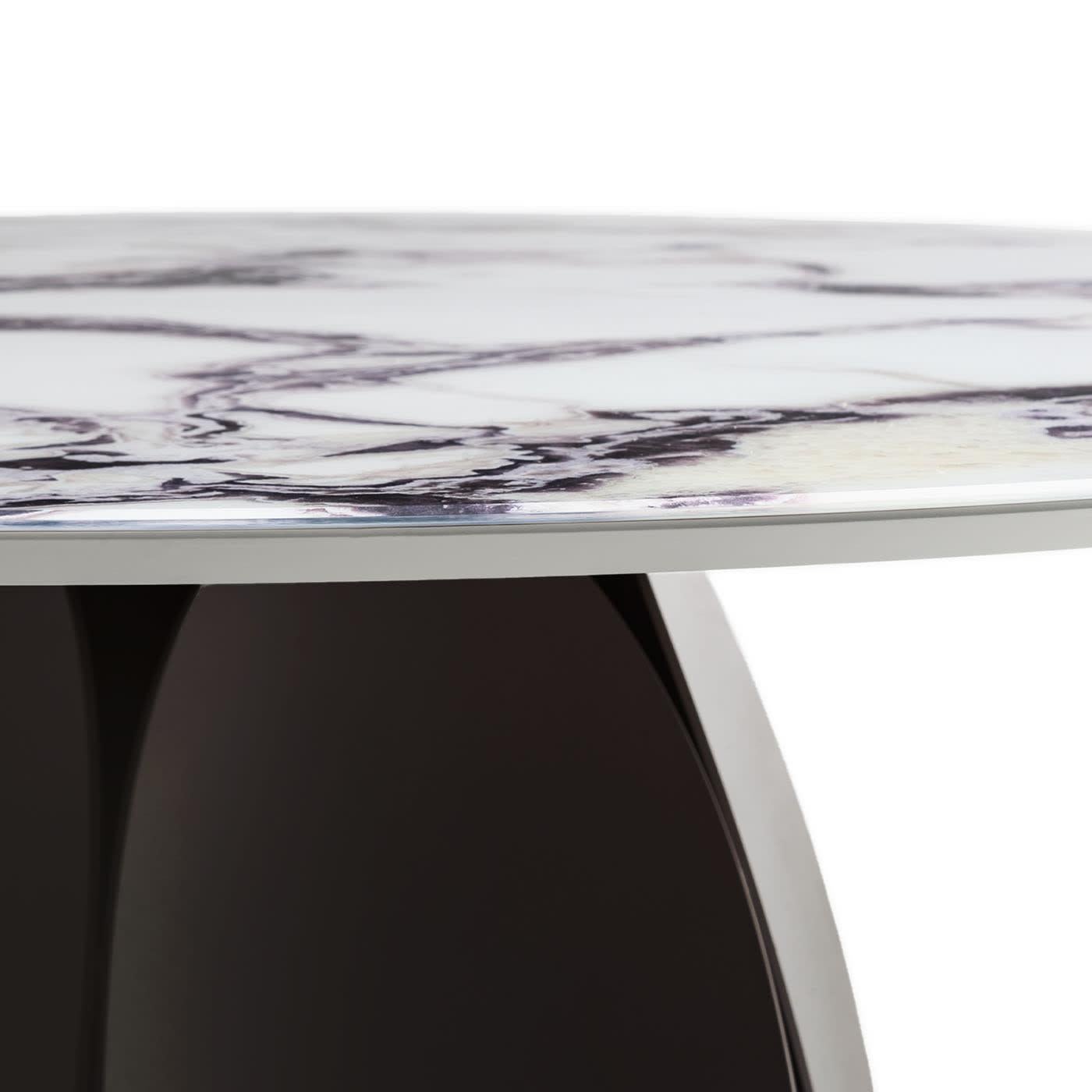 At once sculptural and ethereal, this table reveals its romantic inspiration at first glance, when the eye gets captured by the tulip-petal-like elements making up its calendered metal base varnished with epoxy powders. An intriguing Trinity marble