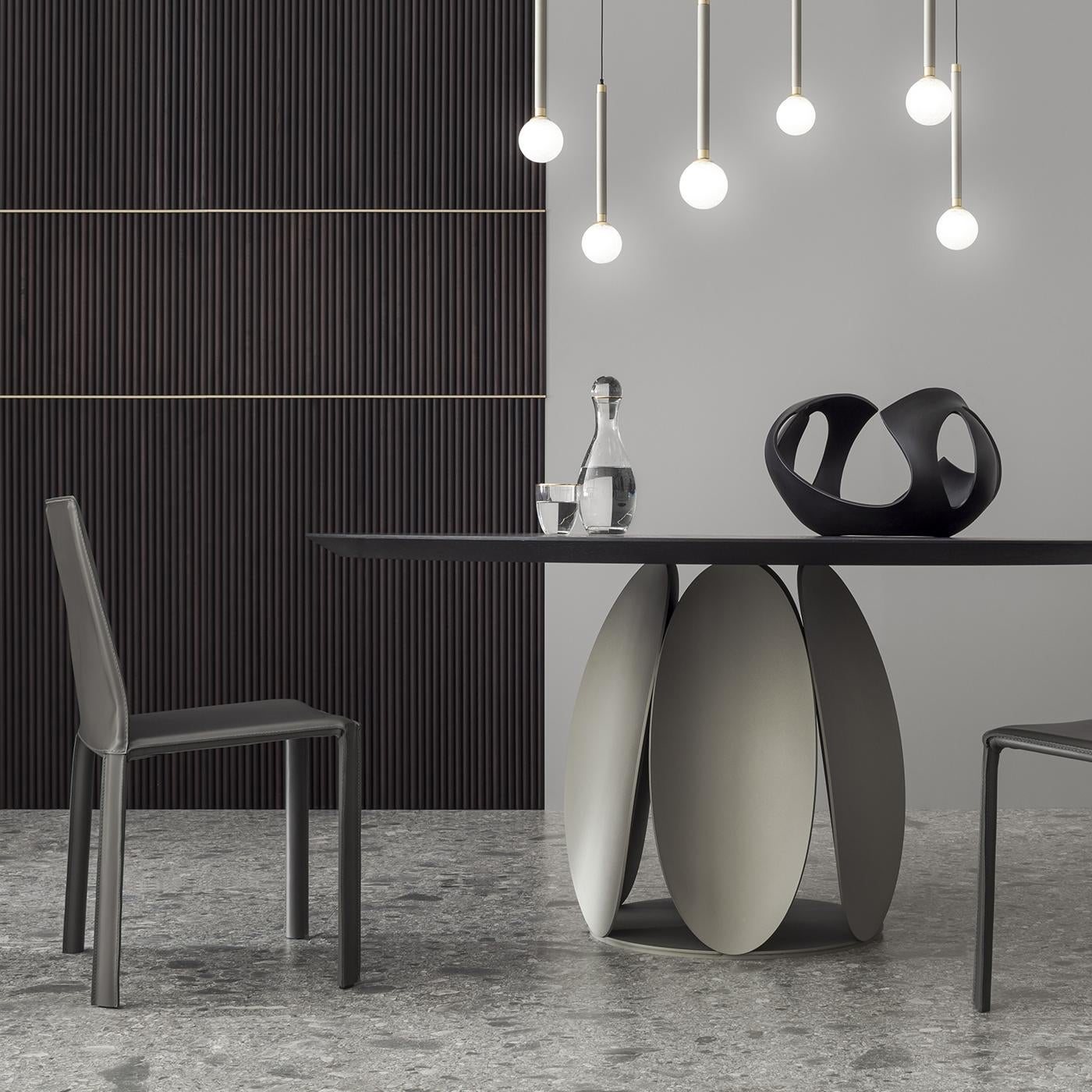 Dieser charmante Tisch ist von Tulpen inspiriert und versprüht einen skulpturalen Charme. Eine Scheibe dient als Basis für die blütenblattähnlichen, gerollten Metallelemente, die alle die gleiche, champagnerfarbene Epoxid-Pulverlackierung aufweisen