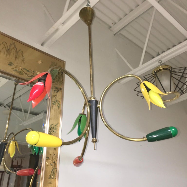 Saturday Sale


Colorful Italian modernist 1950's chandelier. Each of the three curved brass arms has an enameled aluminum come which has been shaped in the form of a flower with petals. and a tapered enameled aluminum bullet cone.  The former have