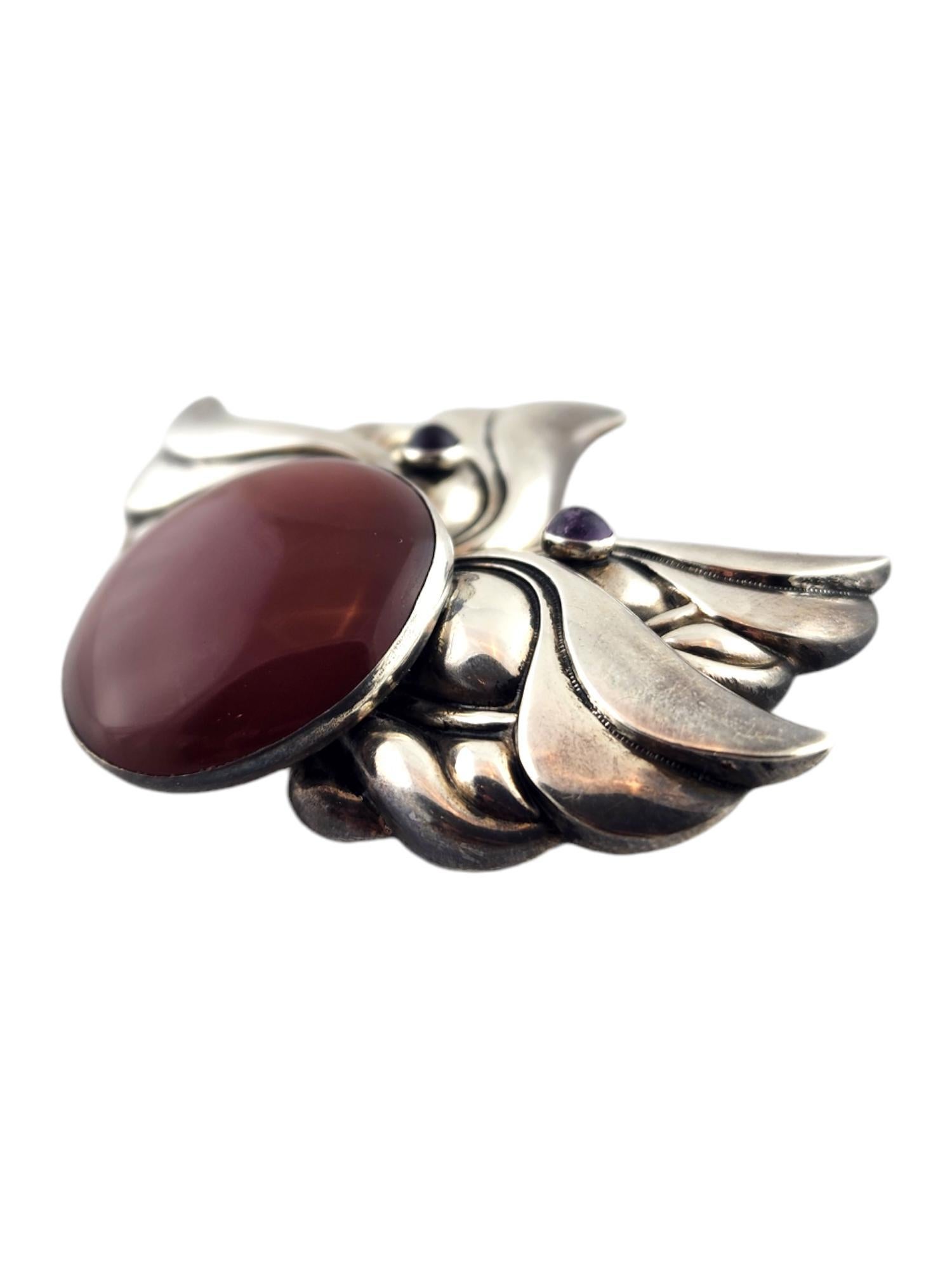Tulla Booth Sterling Silver Red and Purple Cabochon Stone Brooch/Pin

This gorgeous brooch/pin by Tulla Booth was meticulously crafted from sterling silver and features one large red cabochon stone and two smaller purple cabochon