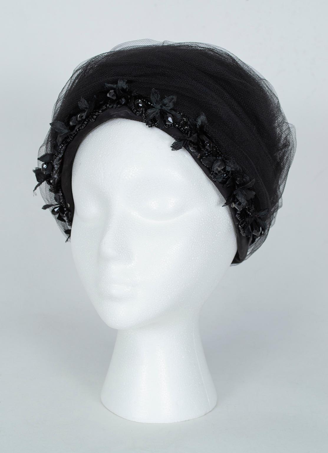 Not for the faint of heart, this frothy cocktail hat will add inches to your height and ensure you leave a memorable impression. Dangling faceted beads around the bottom edge add subtle sparkle and frame the face, while yards of tulle create a