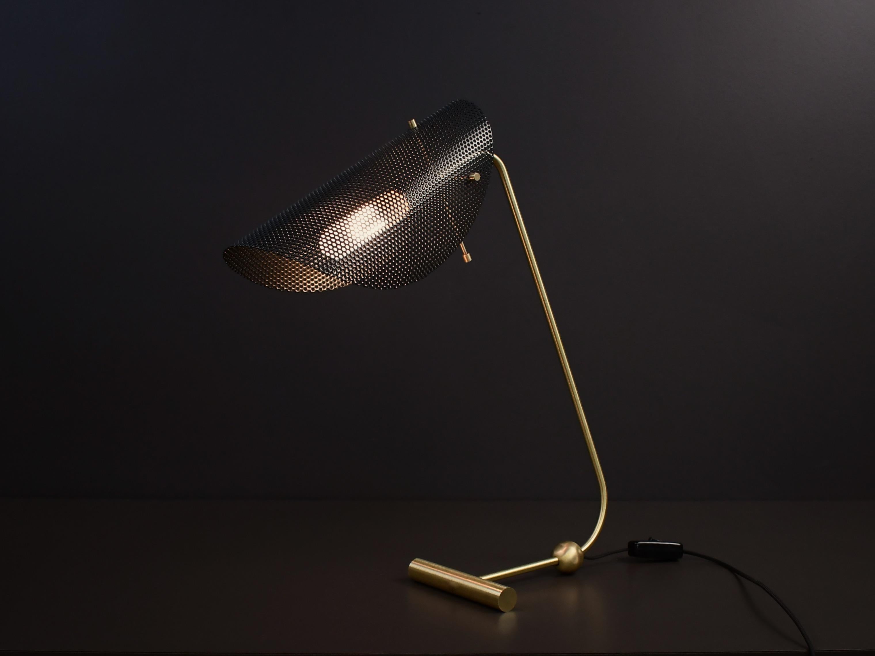 La lampada da tavolo o da scrivania Tulle è un pezzo architettonico che si adatta bene sia agli interni moderni che a quelli di transizione. Qui è raffigurato con lo smalto nero opaco e la ferramenta in ottone naturale. Disponibile in uno dei nostri