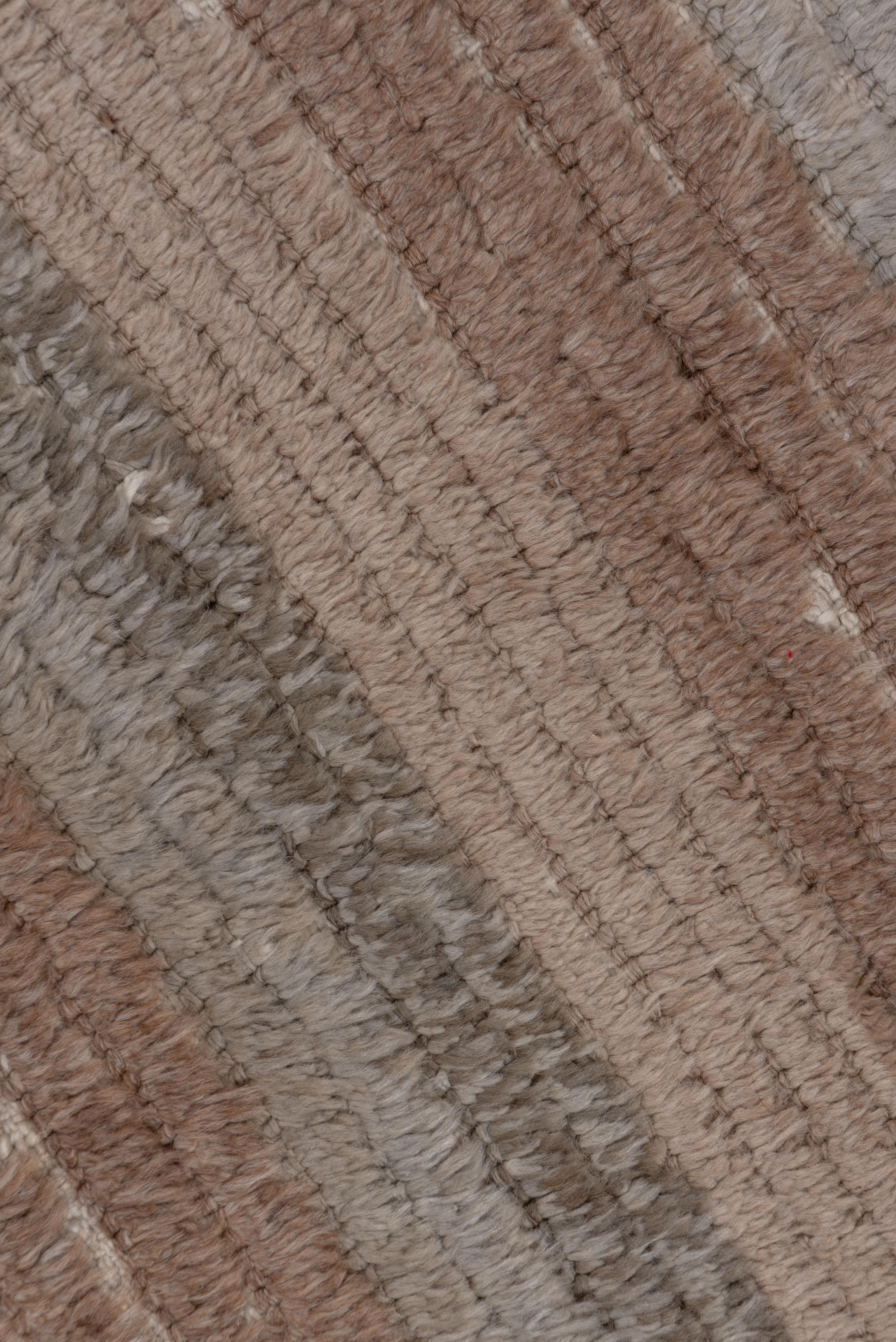 In tones of brown, sand, khaki, tan and beige, this long and flat pile Turkish village scatter shows numerous wefts between knot rows. There are no border and the earth tones run straight across. The condition is very good.