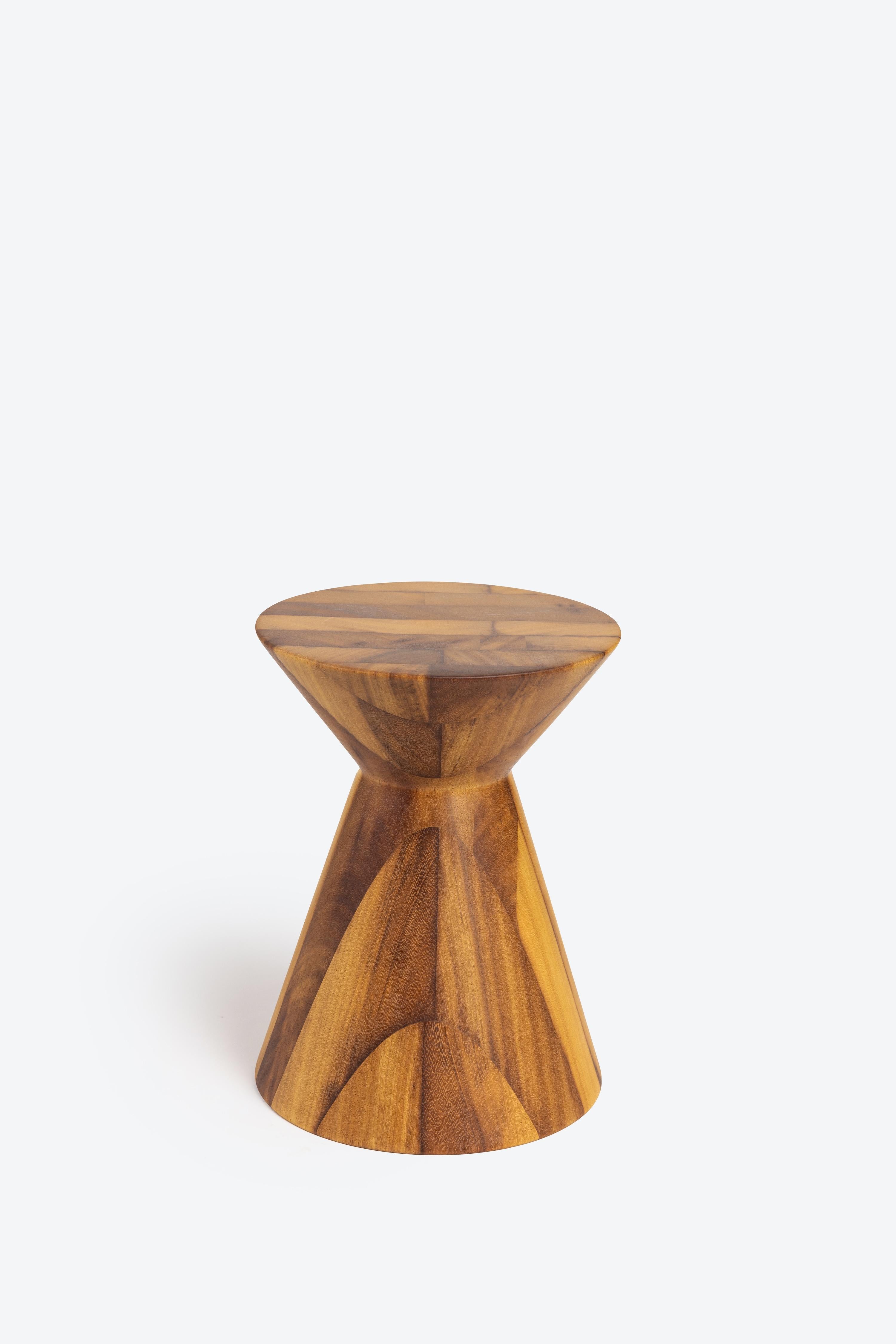 A solid wood stool turned on the lathe with three tiers. It can be used for seating or as a side table. It stands at 16 inches tall x 12 inches in diameter and weighs roughly 30 pounds. Made from Iroko wood. Each stool is unique based on the