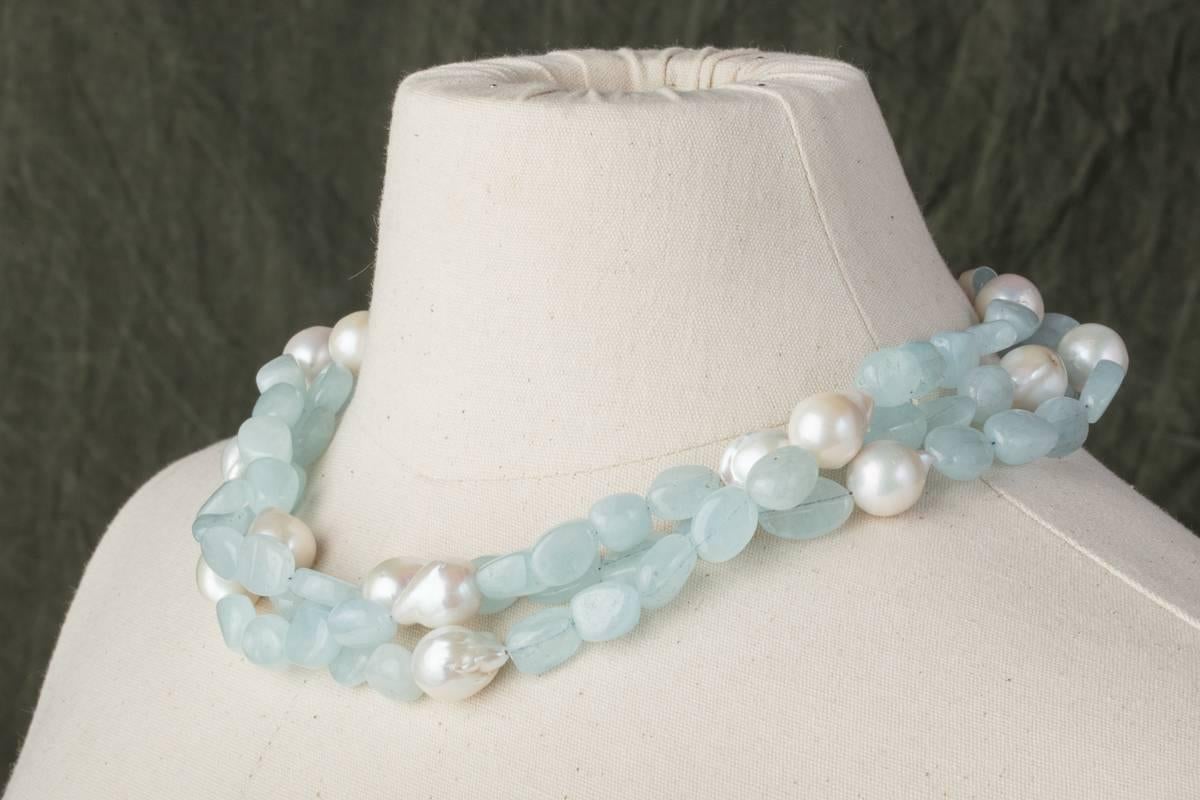 A triple strand of tumbled aquamarines and baroque pearls with a sterling silver and labradorite clasp.  Designed and created by Deborah Lockhart Phillips.