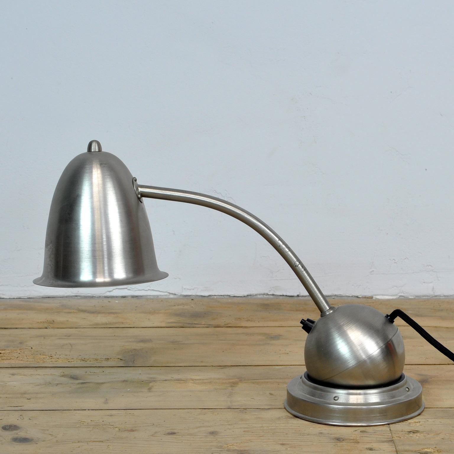 Rare nickel-plated desk lamp, ca 1930.
The lamp is called tumbler, in Dutch it is called tuimelaar/duikelaar.
The shade can be adjusted into different positions, as the counterweight of the ball keeps the lamp in balance. The lamp rests on a