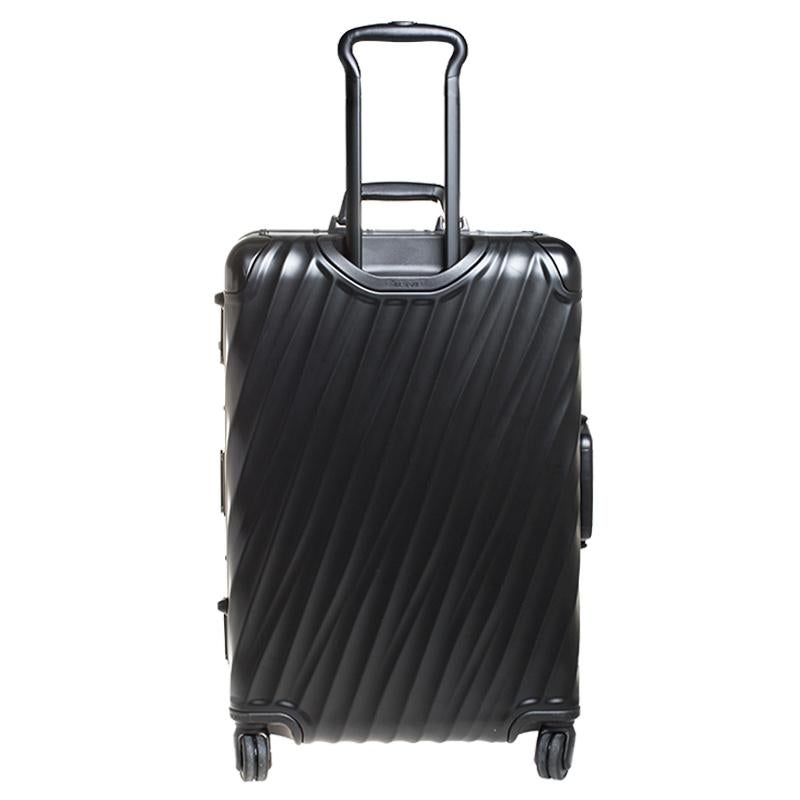 This Short Trip Packing Case 19 Degrees Luggage bag from TUMI is made from black aluminium. Equipped with four wheels that offer unrestrained movement, the bag has a top carry handle along with zippers to ensure security. It boasts a nylon-lined
