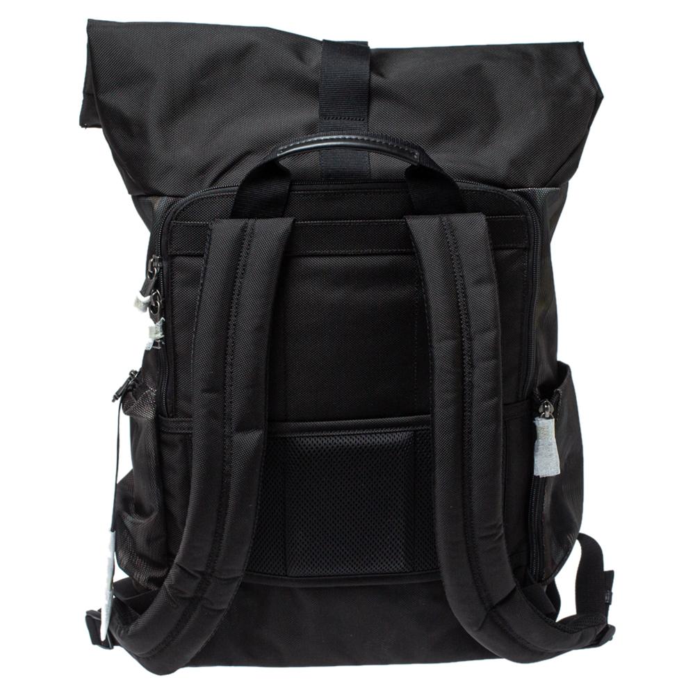This lightweight and reliable backpack by TUMI is made from nylon into a functional design. The bag features a roll top with safety buckle fastening, zip pockets on the exterior, and a spacious main interior. It is complete with a flat top handle