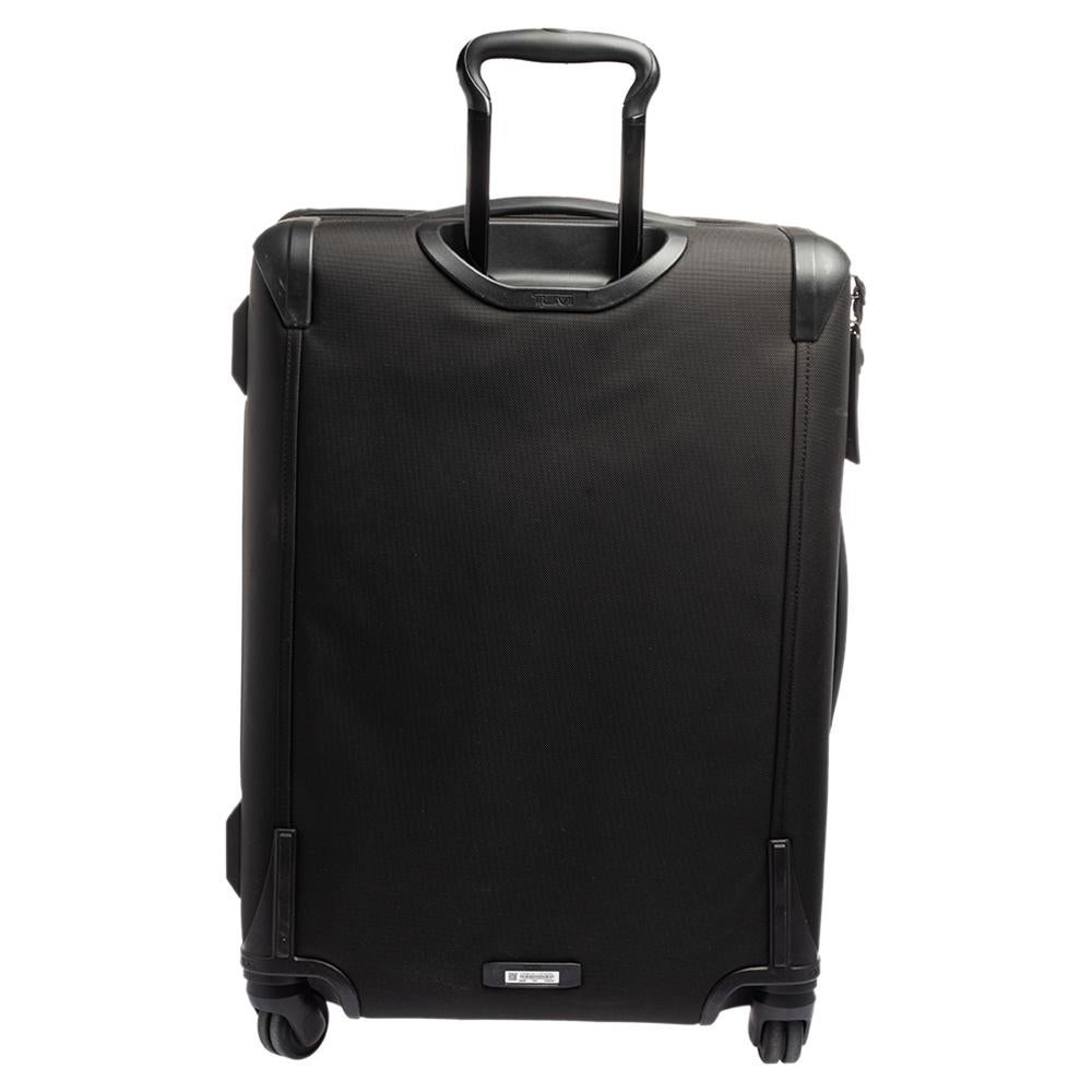 Diese Alpha 2 Gepäcktasche wurde von TUMI in einem schwarzen Farbton entworfen. Dieser Koffer mit 4 Rädern verfügt über ein großes und ein kleines Reißverschlussfach mit einem Markenlogo auf der Vorderseite. Diese luxuriöse Tasche ist aus Nylon