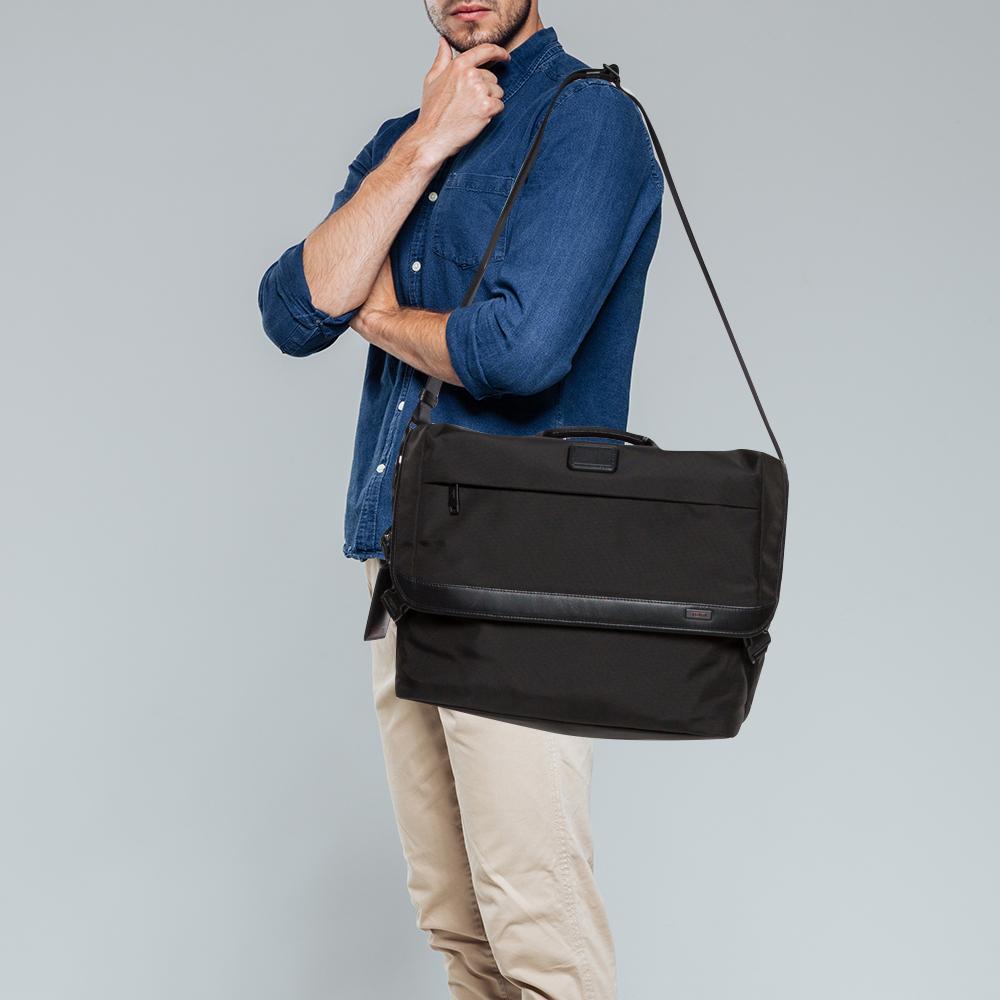 Diese Laptoptasche von Tumi ist aus Nylon gefertigt. Die praktische Tasche verfügt über einen einzelnen oberen Griff, einen Schulterriemen und Reißverschlusstaschen auf der Vorder- und Rückseite. Das geräumige Hauptfach ist mit Nylon gefüttert und