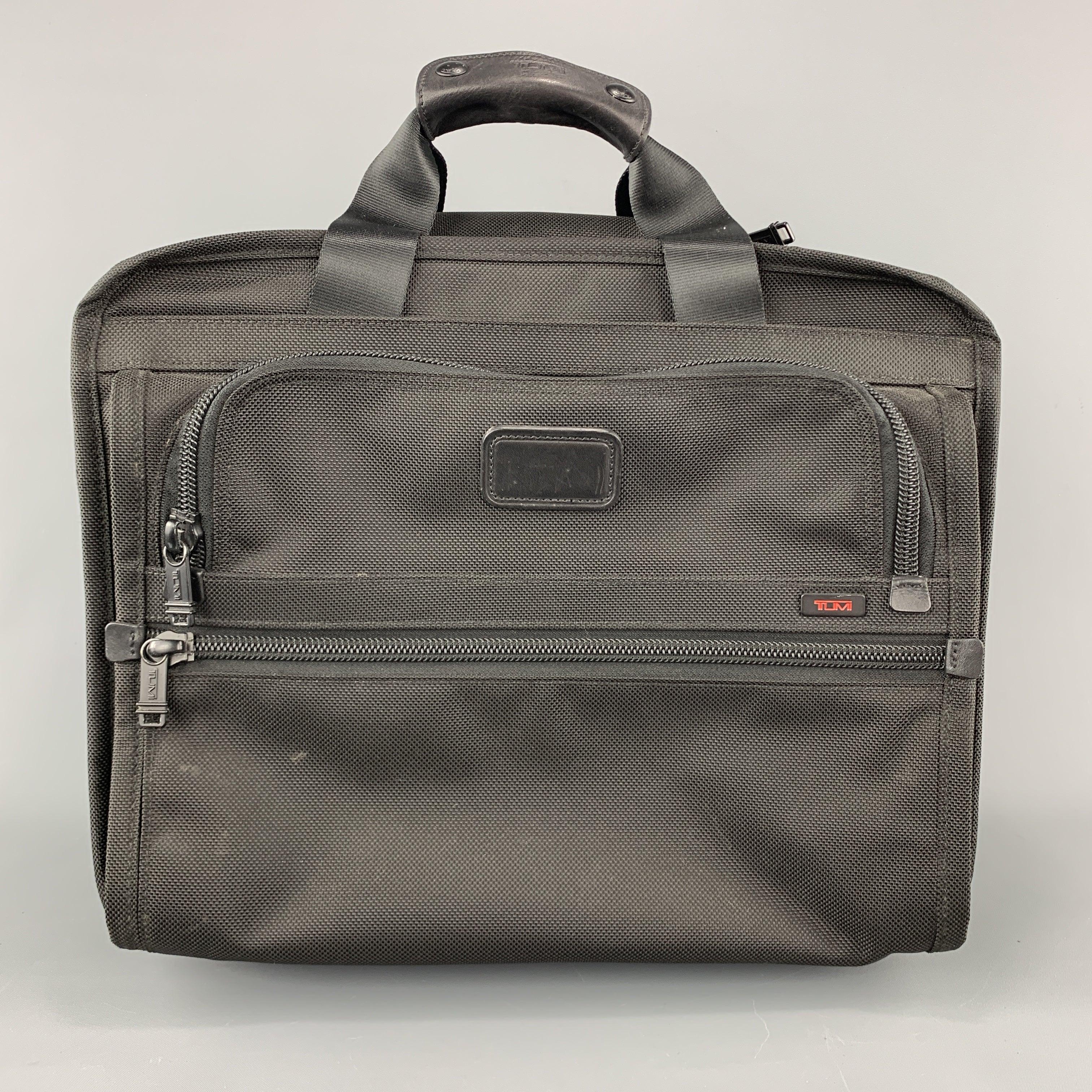 TUMI roller suitcase comes in black nylon canvas with zip pockets, optional retractable handle, top handles, and inner compartments. Wear throughout. As-is.Fair
Pre-Owned Condition. 

Measurements: 
  Length: 16 inches Width:
9 inches Height:
13.5