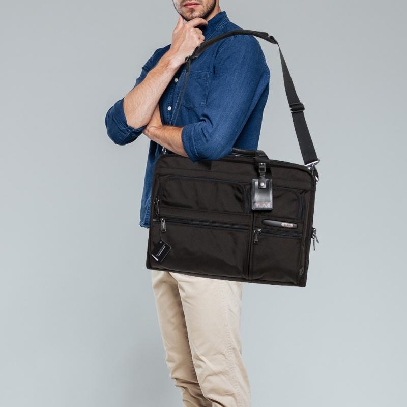 This Gen 4.2 Organizer Portfolio briefcase from TUMI is designed to conveniently assist you. Crafted using nylon, it features two top handles, a removable shoulder strap, and a smart black shade. Equipped with multiple pockets and spacious