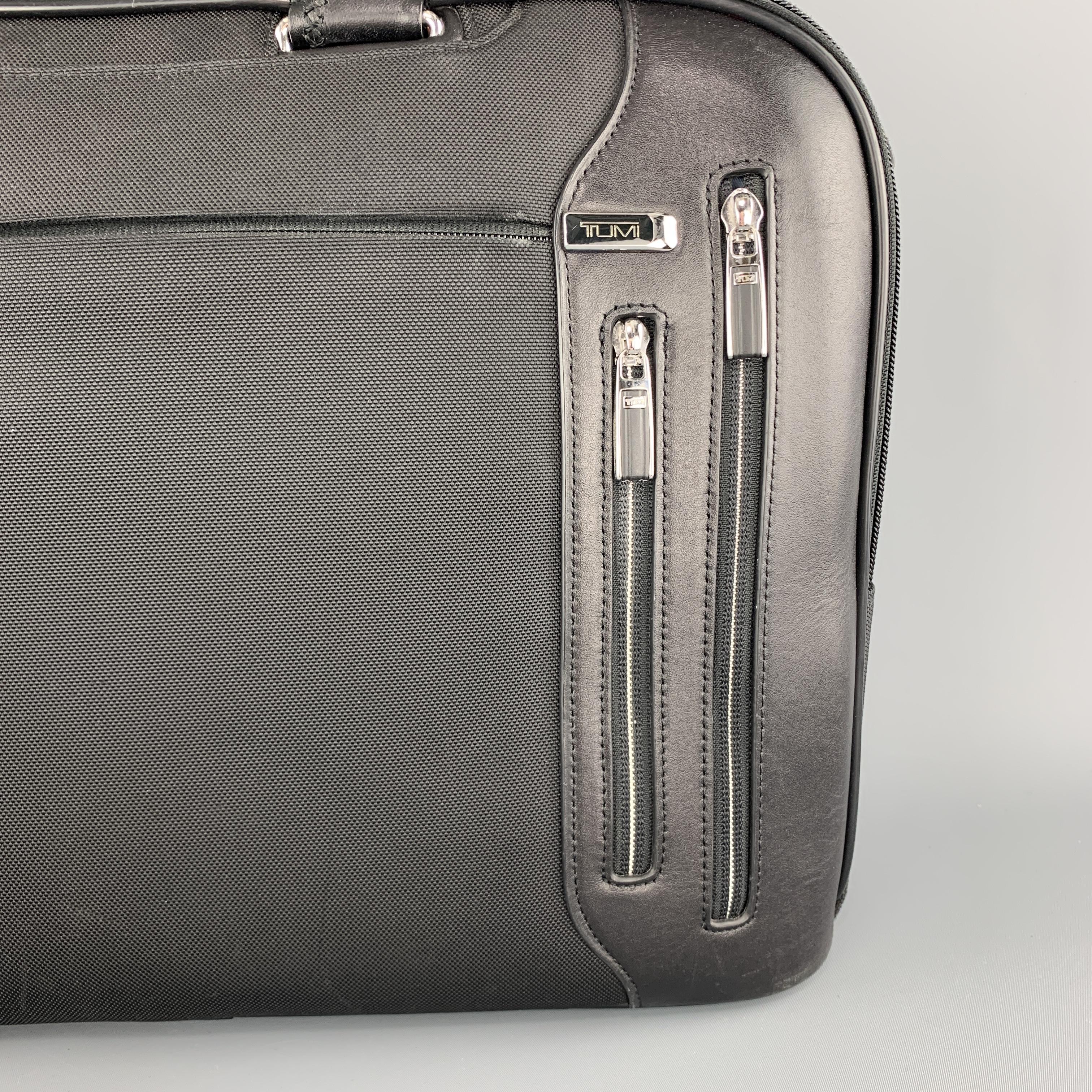  TUMI briefcase laptop bag comes in nylon canvas with leather details, multiple zip pockets, leather double top handles, detachable strap, multi section interior, and pencil case. 

Very Good Pre-Owned Condition.

Measurements:

Length: 17