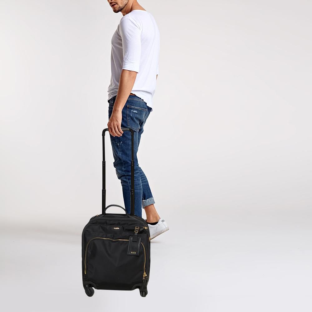 TUMI is a brand par excellence when it comes to travel accessories! Crafted from high-grade nylon, this luggage bag features front zip pockets, a telescopic handle, a carry handle, and four wheels. The zip closure opens to a nylon interior furnished