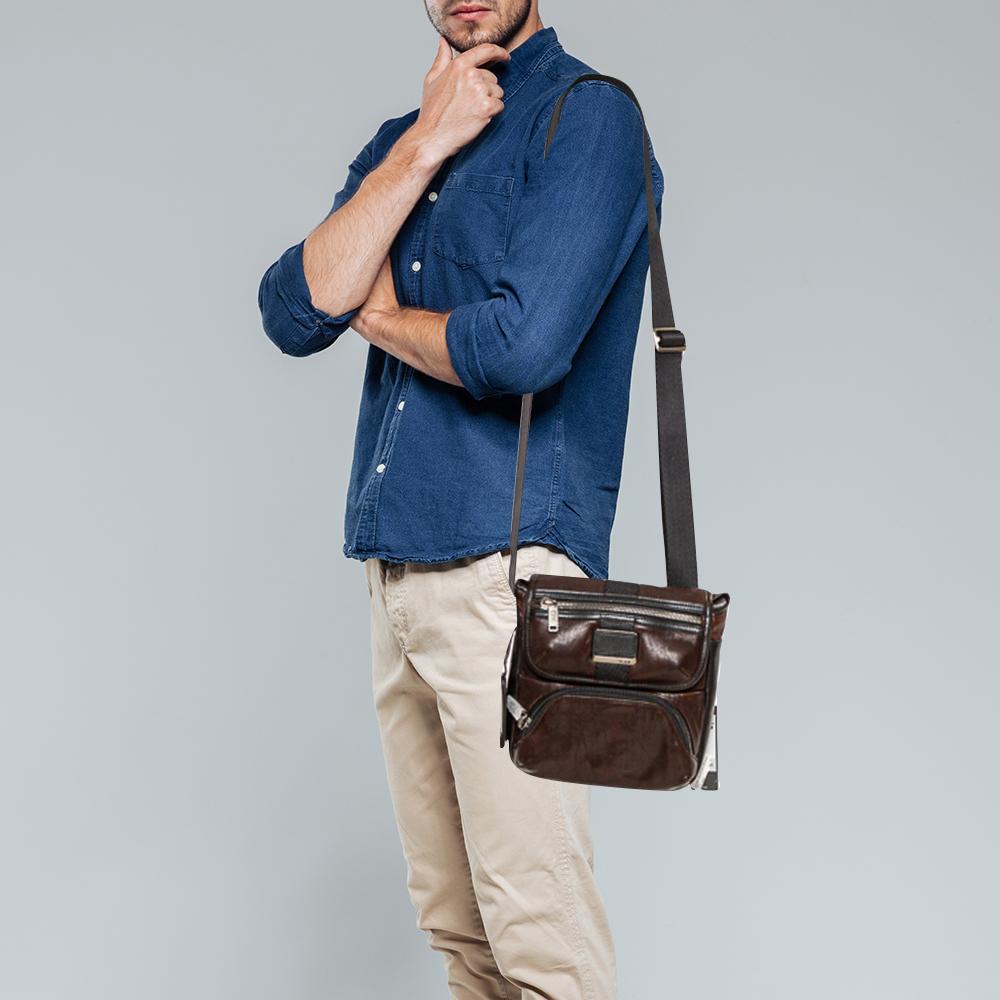 This crossbody bag from Tumi is a reliable accessory. Crafted from leather, the bag comes with dual zip pockets on the front and a brand logo detailing and opens to a fabric interior that is spacious. It is complete with an adjustable shoulder