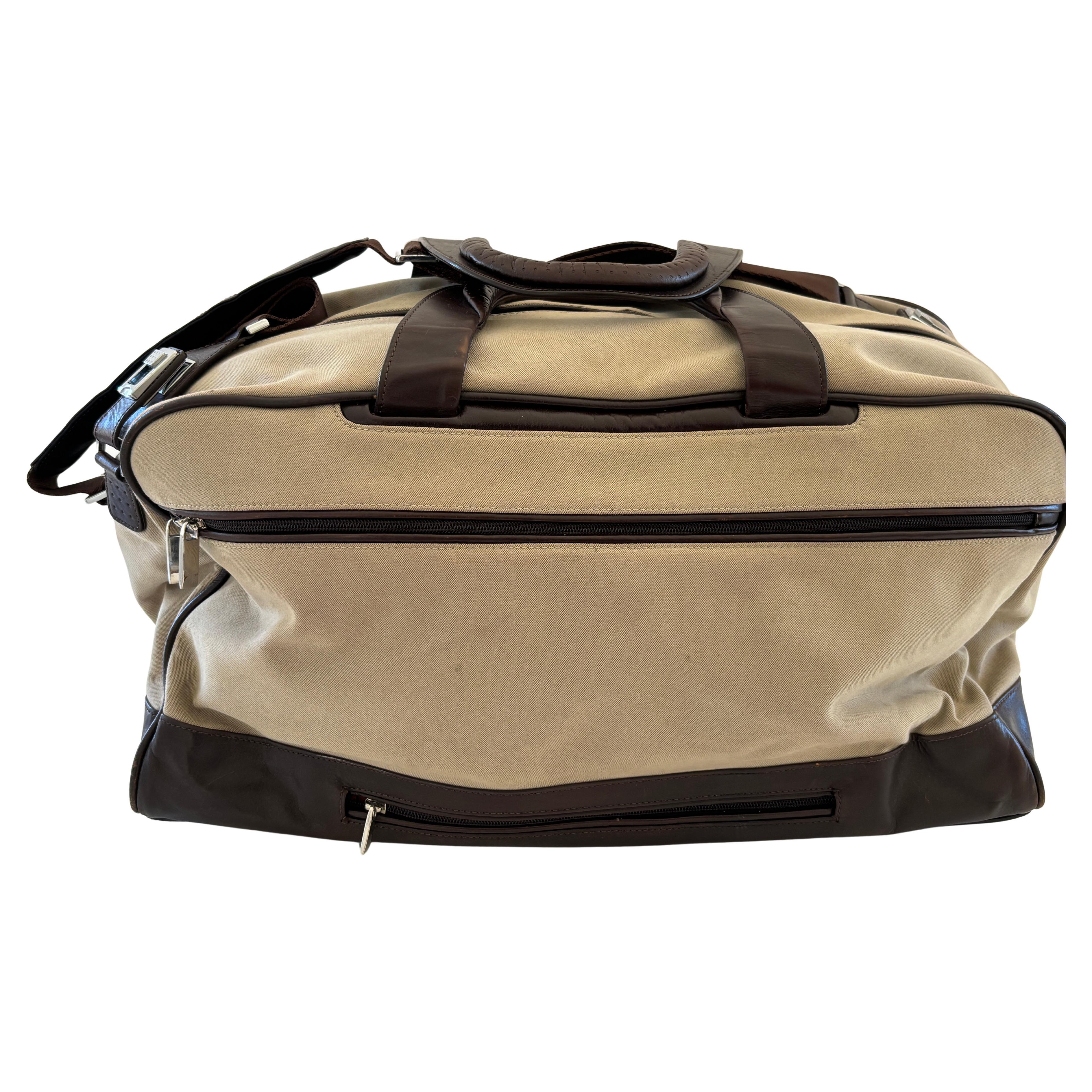 TUMI Canvas and Leather Travel Bag.
TUMI canvas and leather travel bag, expertly designed for both style and utility. Crafted from durable beige canvas with luxe leather trim and handles, this versatile satchel transitions seamlessly from gym