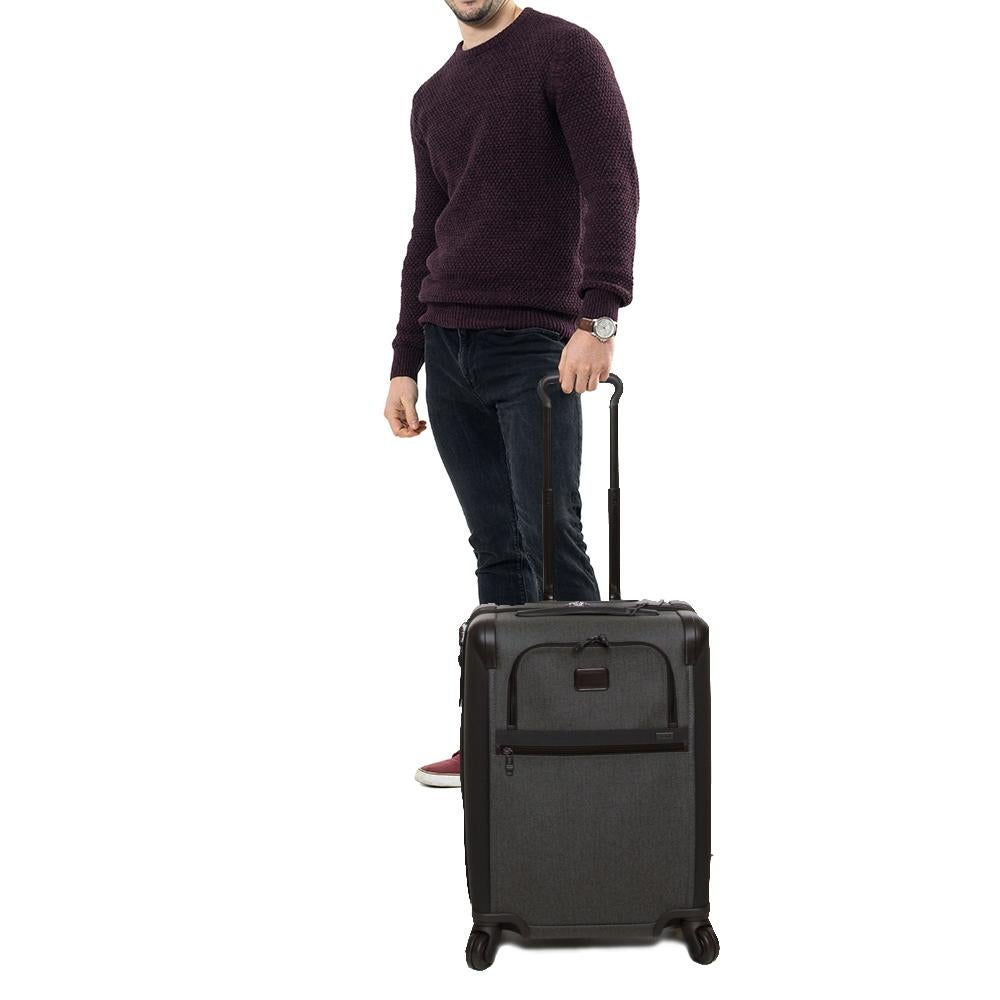 This Alpha II luggage bag is designed by TUMI in a grey-black combination. This 4 wheeled luggage case features a big and one small zipper compartment with the brand logo at the front. Crafted from nylon, this luxury opens to a wide nylon-lined