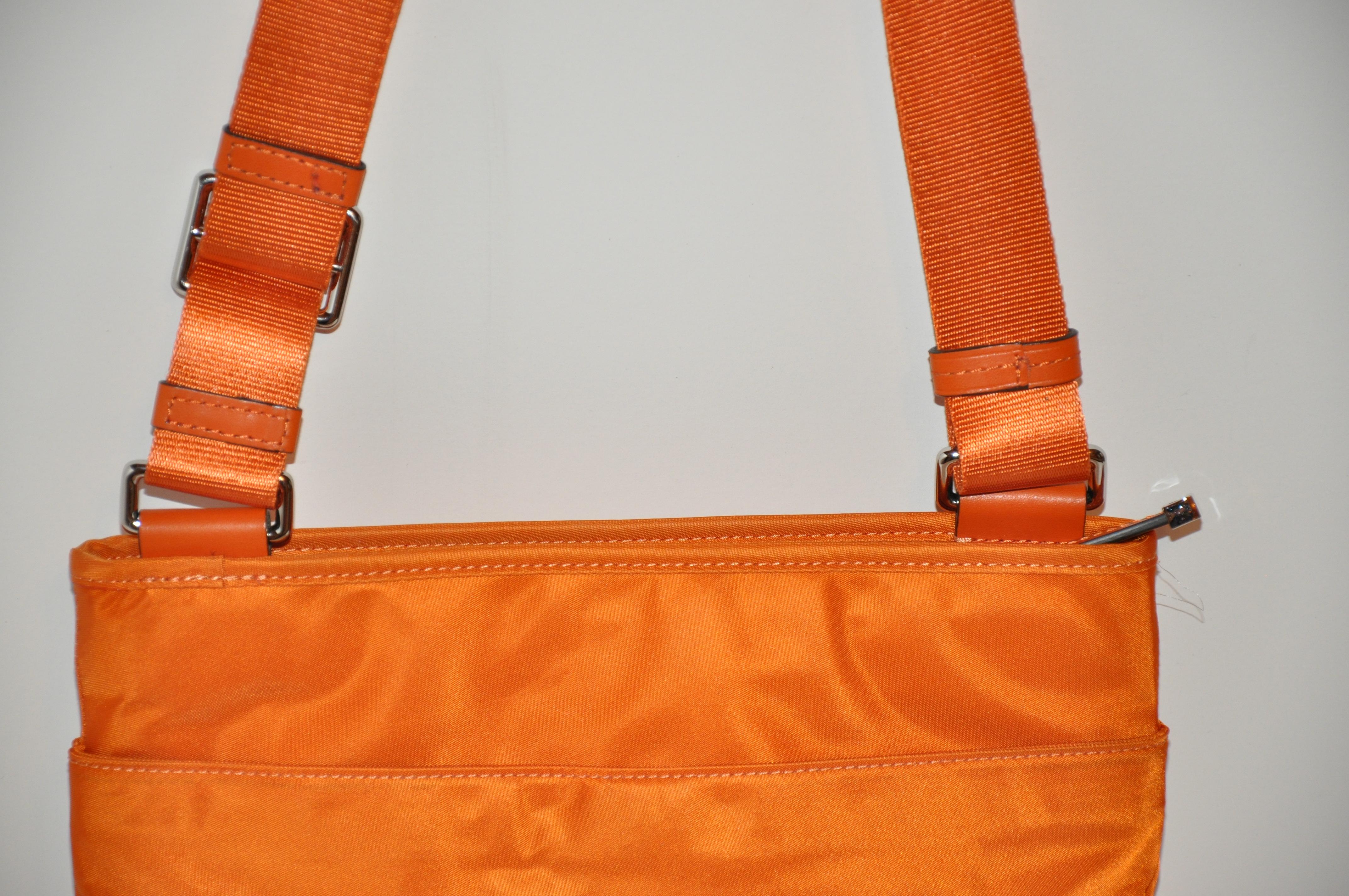        Tumi wonderful warm tangerine crossbody shoulder bag with adjustable shoulder straps, has a zippered compartment in front. The backside has an open compartment. The interior has 2 compartments. Item measures 11 inches in length, 10 inches in