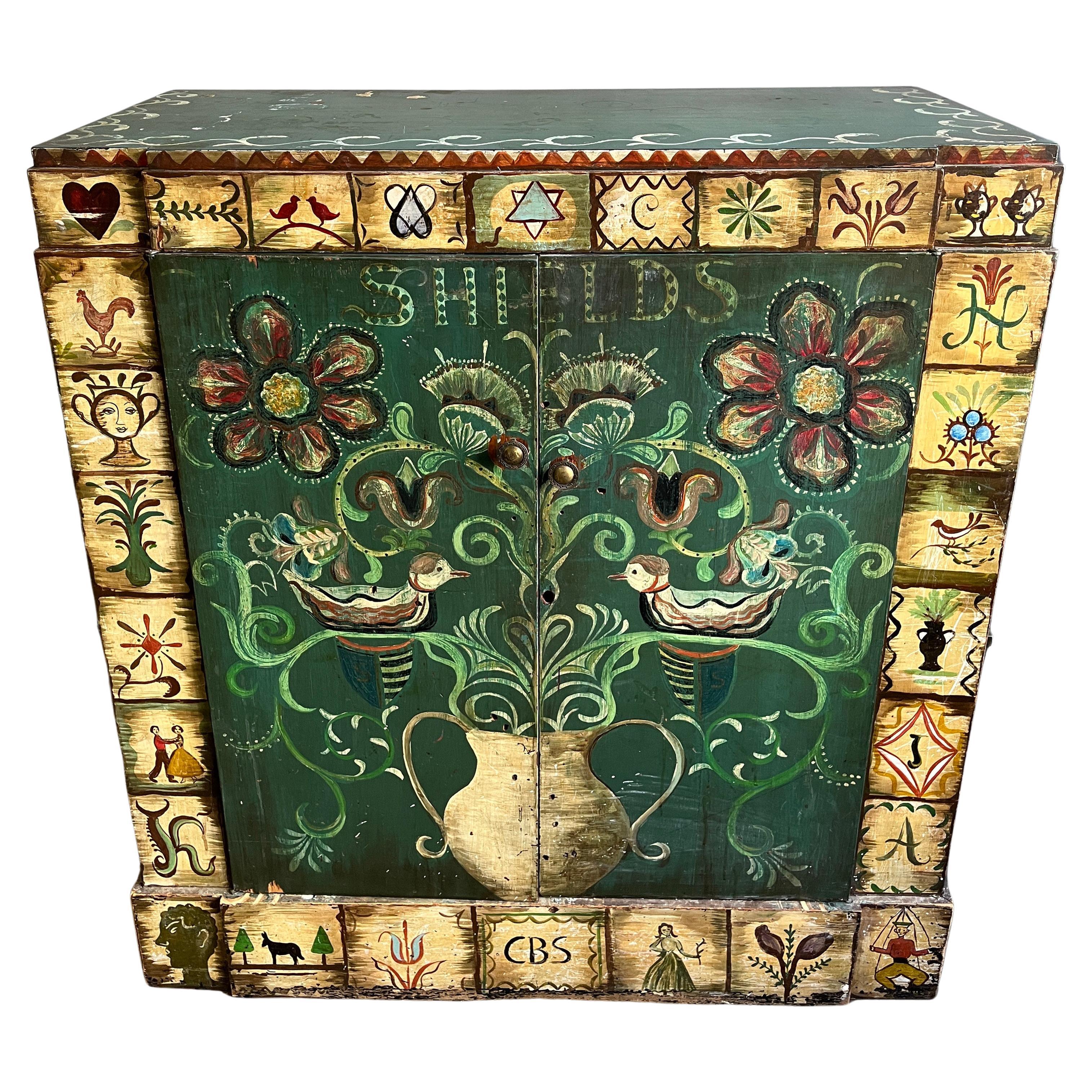This beautiful hand painted wedding cabinet hand constructed by the Shield family. This turn of the century chest was lovingly painted with beautiful imagery. Throughout the years, this piece has been reworked and modified as evident by an