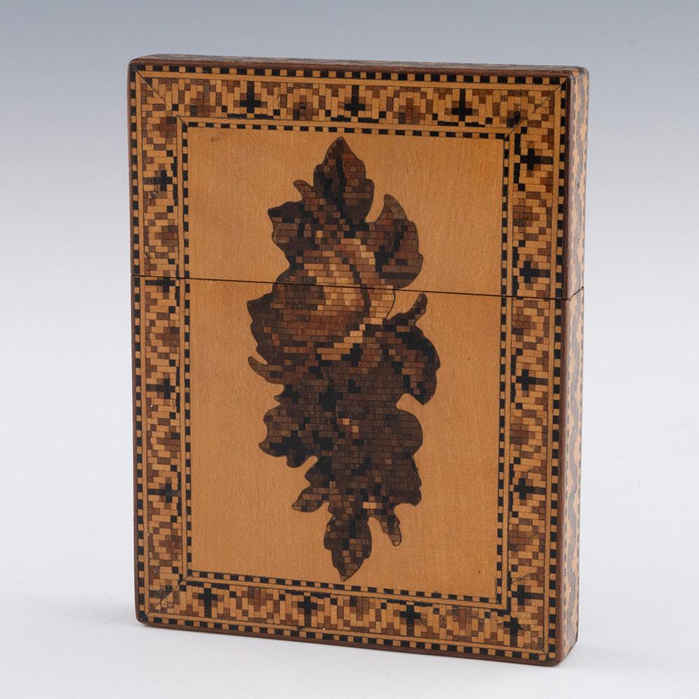 Heading : Tunbridge ware card case George Wise Jr

Date : c1865

Period : Victoria

Origin : Tonbridge, Kent

Decoration : Central floral mosaic with border of crosses to one side and geometric pattern to the other. George Wise label to the
