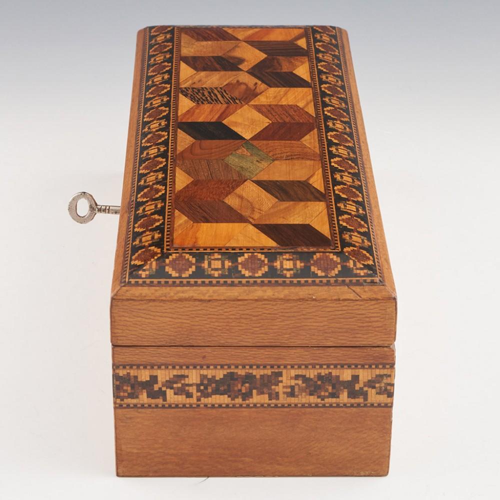 Heading : Tunbridge ware cigar or cigarette box
Date : c1925
Period : George V
Origin : Tunbridge Wells, Kent
Decoration : Perspective cubes within geometric border to the cover. Side panels decorated with folaite banding. The inside of the cover